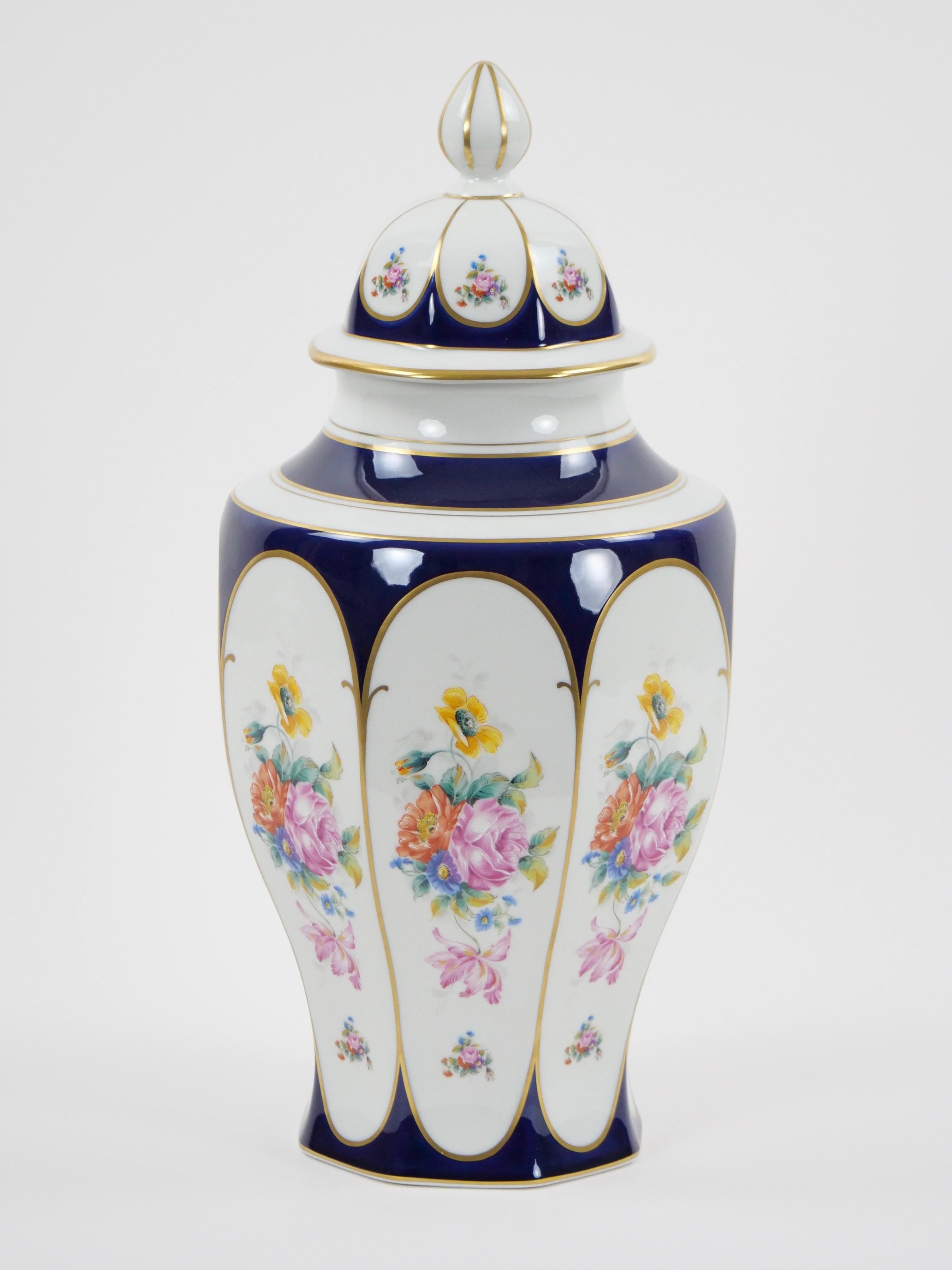 Step into a world of timeless elegance with this exceptional early 20th century German floral hand-painted and gilt porcelain urn. Crafted with meticulous attention to detail, this urn is a masterpiece that seamlessly marries artistry and luxury.