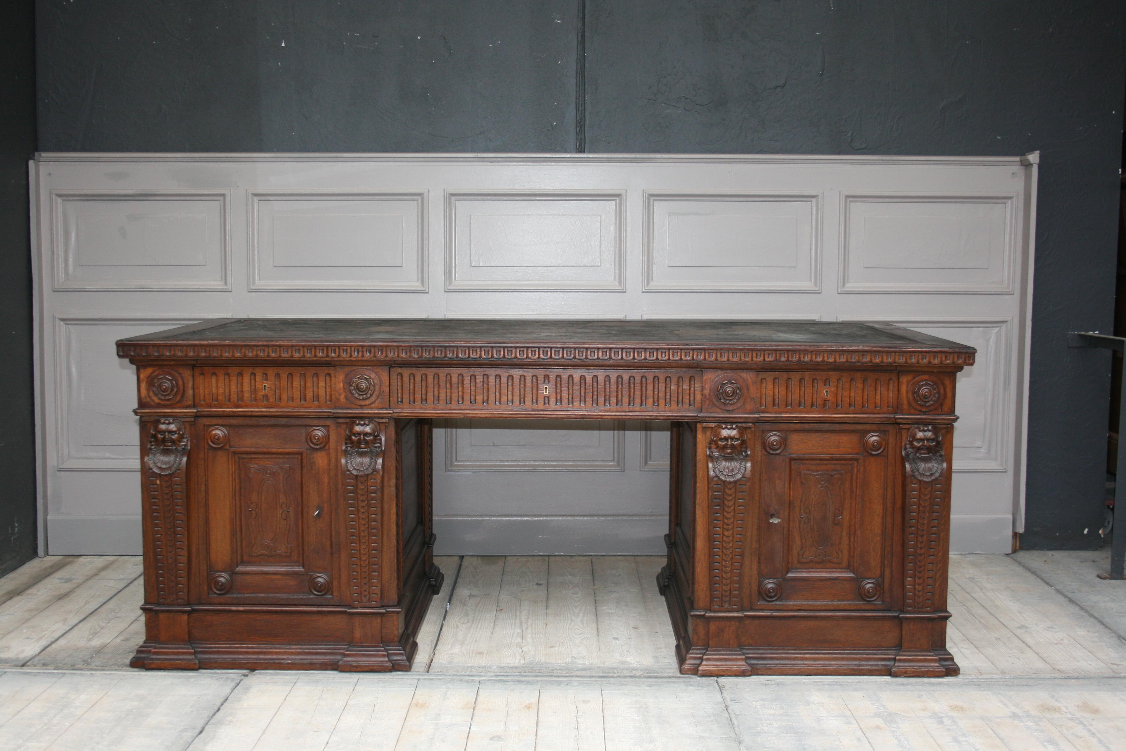 Original German historicism or Renaissance Revival desk from the end of the 19th century.
This stunning desk is usable on both sides and can stand free standing in the room. The entire desk has carvings all around, including 4 grotesque heads on