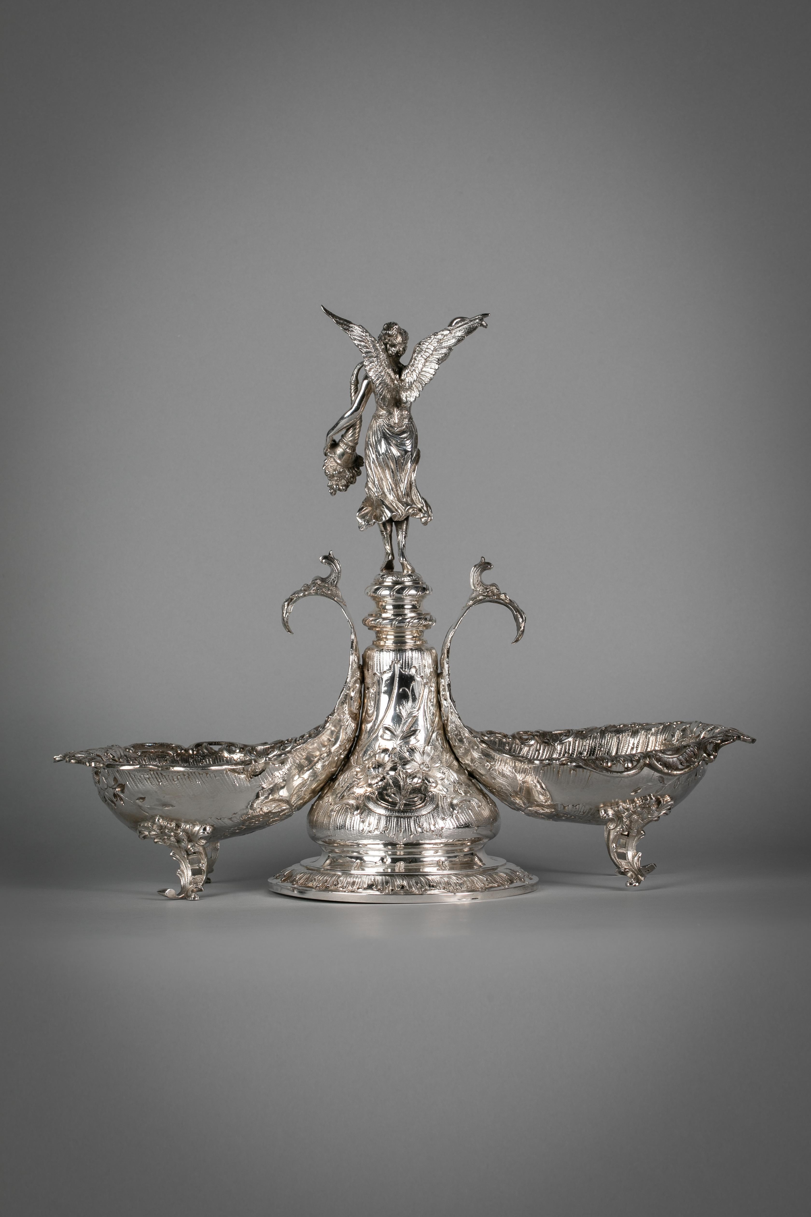 With two large coupes on scroll legs. Surmounted by a winged victory holding a laurel wreath and a cornucopia.