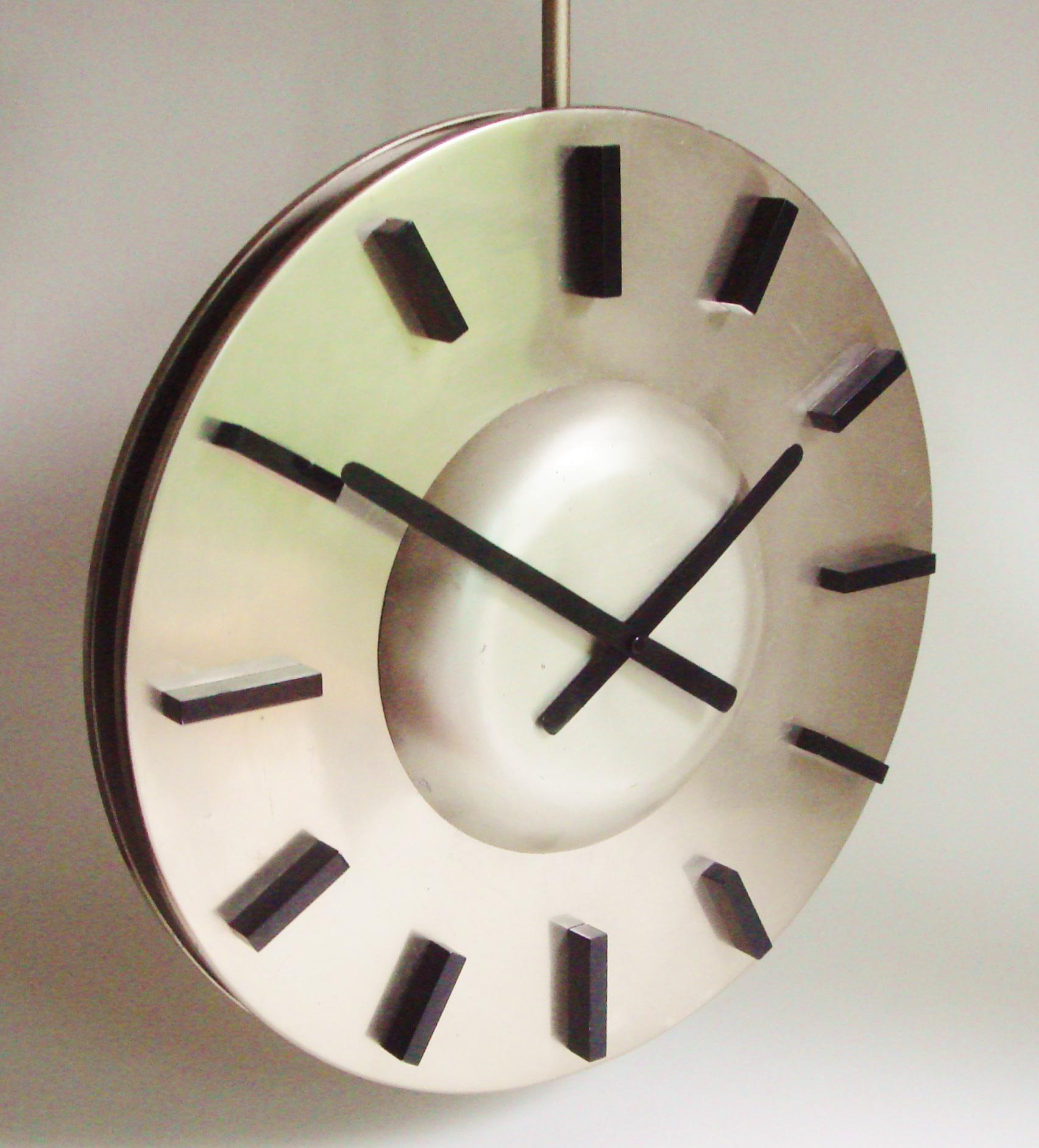 This large and very graphically designed German, Space Age, twin-faced and ceiling mounted clock is one very strong example of midcentury design. The numerals and hands are in black anodized aluminium while the two faces of the clock are in two
