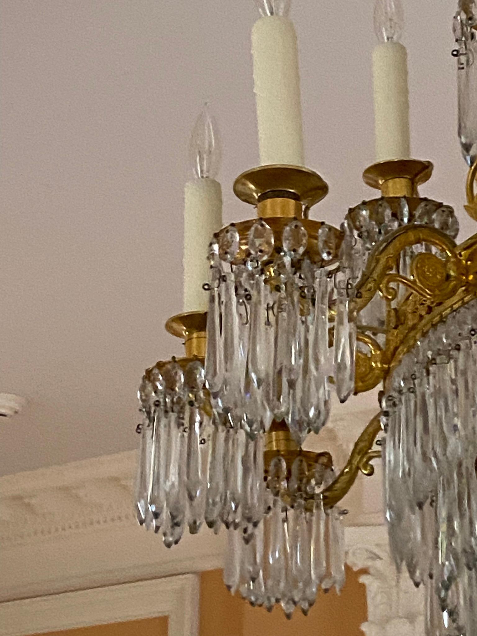 Antique French Empire style gilded bronze chandelier with 18 lights. This has been newly restored and rewired and is ready to ship. This was retrieved from an estate located in Greenwich, Connecticut. Good condition with appropriate wear from age.