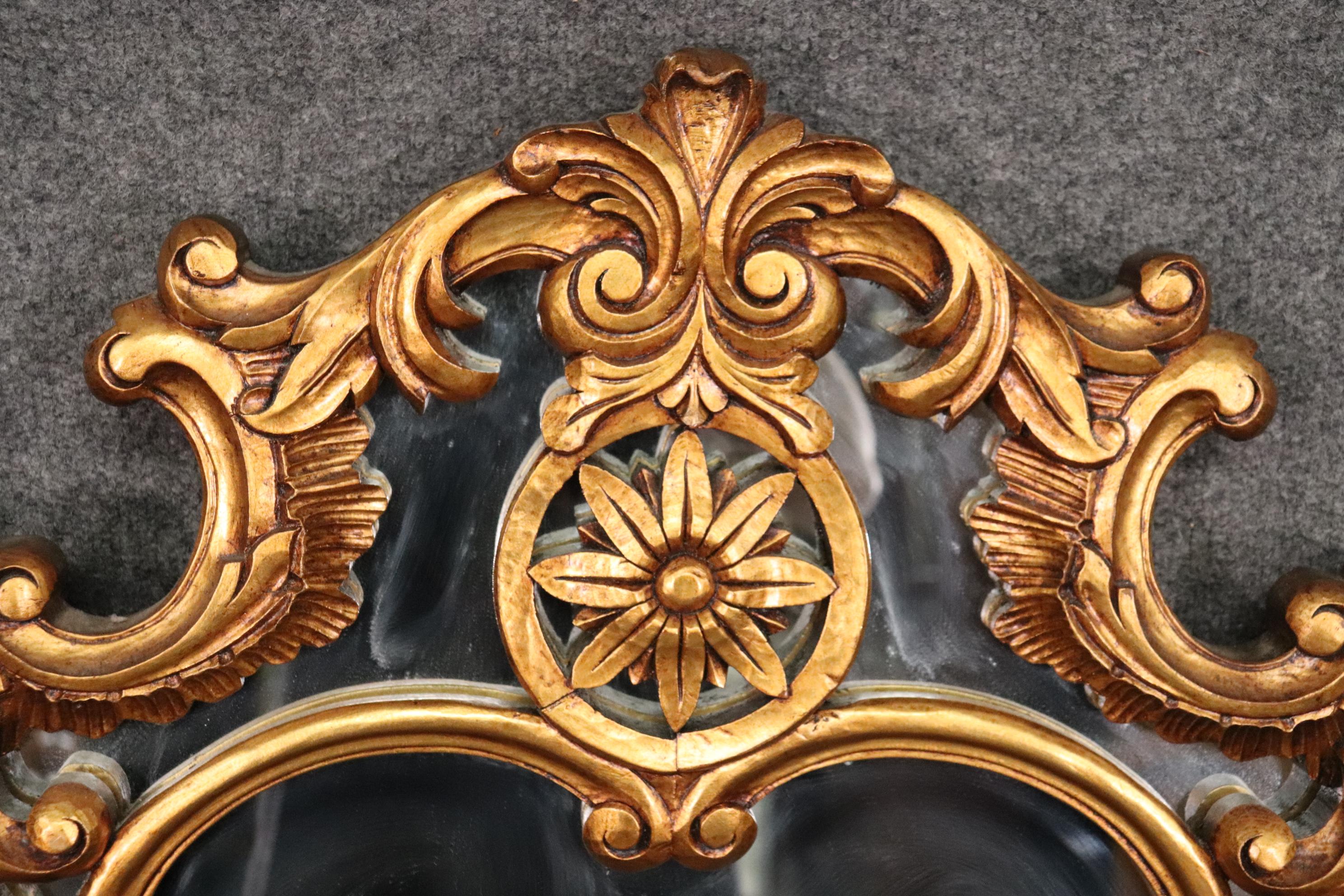This is a gorgeous carved gilded mirror. The mirror is in good condition. The mirror measures 55 tall x 40 wide x 2 deep.
