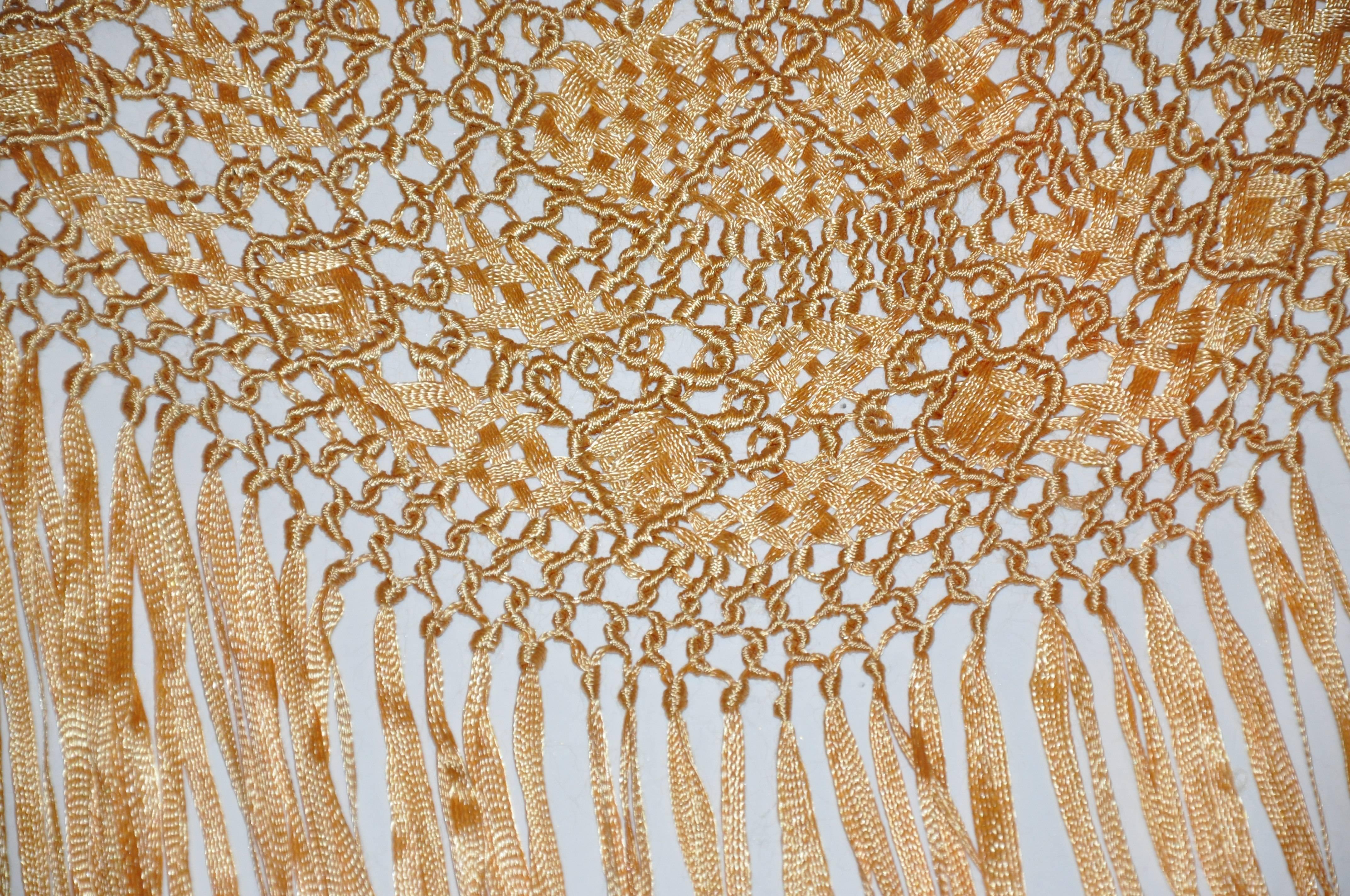        This wonderfully detailed large gilded golden gold fringe scarf with hand-knotted in the art of Macrame with the revival starting in the 1960s as well as the 1990s. The fringe accent measures 12 1/2 inches, with the scarf itself measuring 60