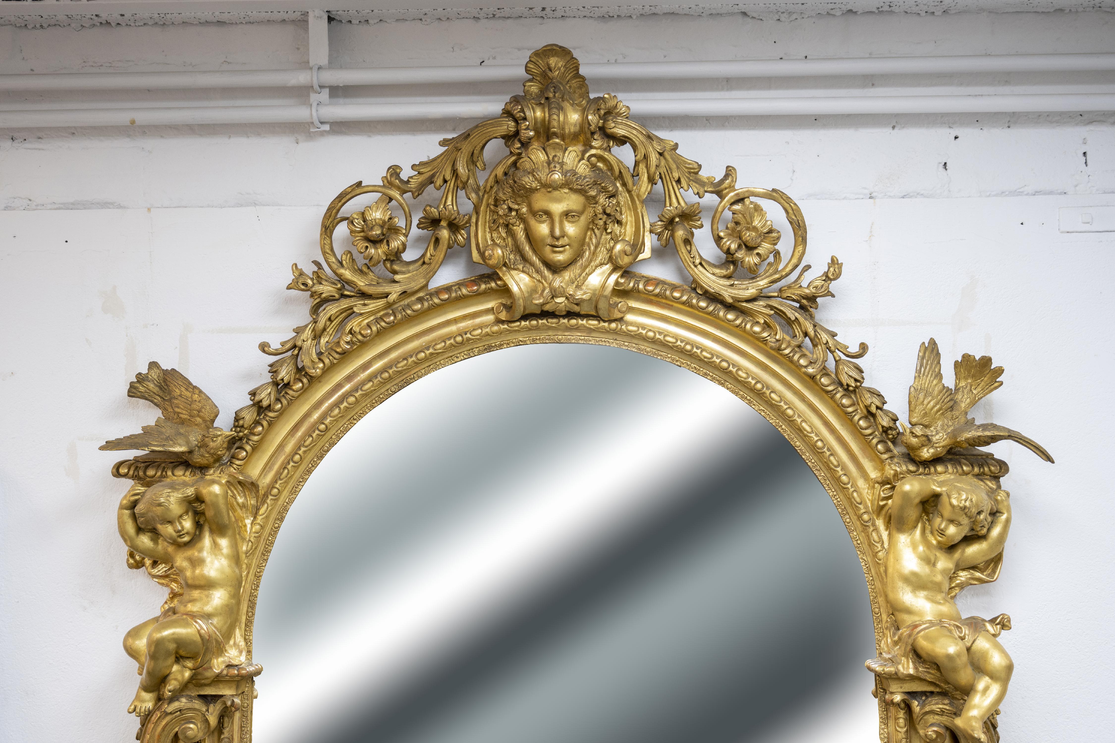 This sumptuous gilded wood trumeau is richly decorated in the style of the Second Empire. The majestic decoration is largely inspired by the ornamental grammar of the past centuries, with scrolls, neoclassical friezes, acanthus leaves and beaded