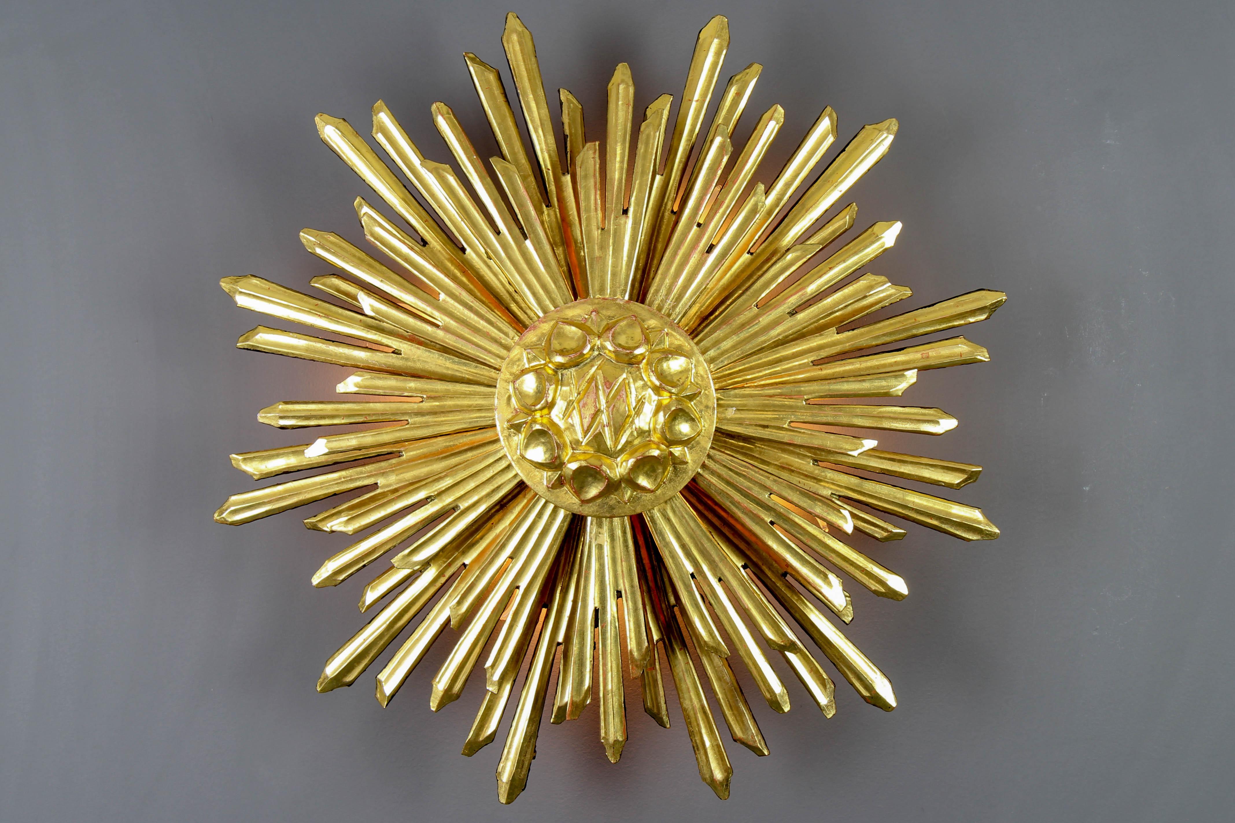 Large gilded wood backlit sunburst wall light, the 1930s
An impressive and beautiful gilded pine wood sunburst-shaped wall light with rays in two layers. The light backlit from four light points is warm and atmospheric and it emanates a beautiful