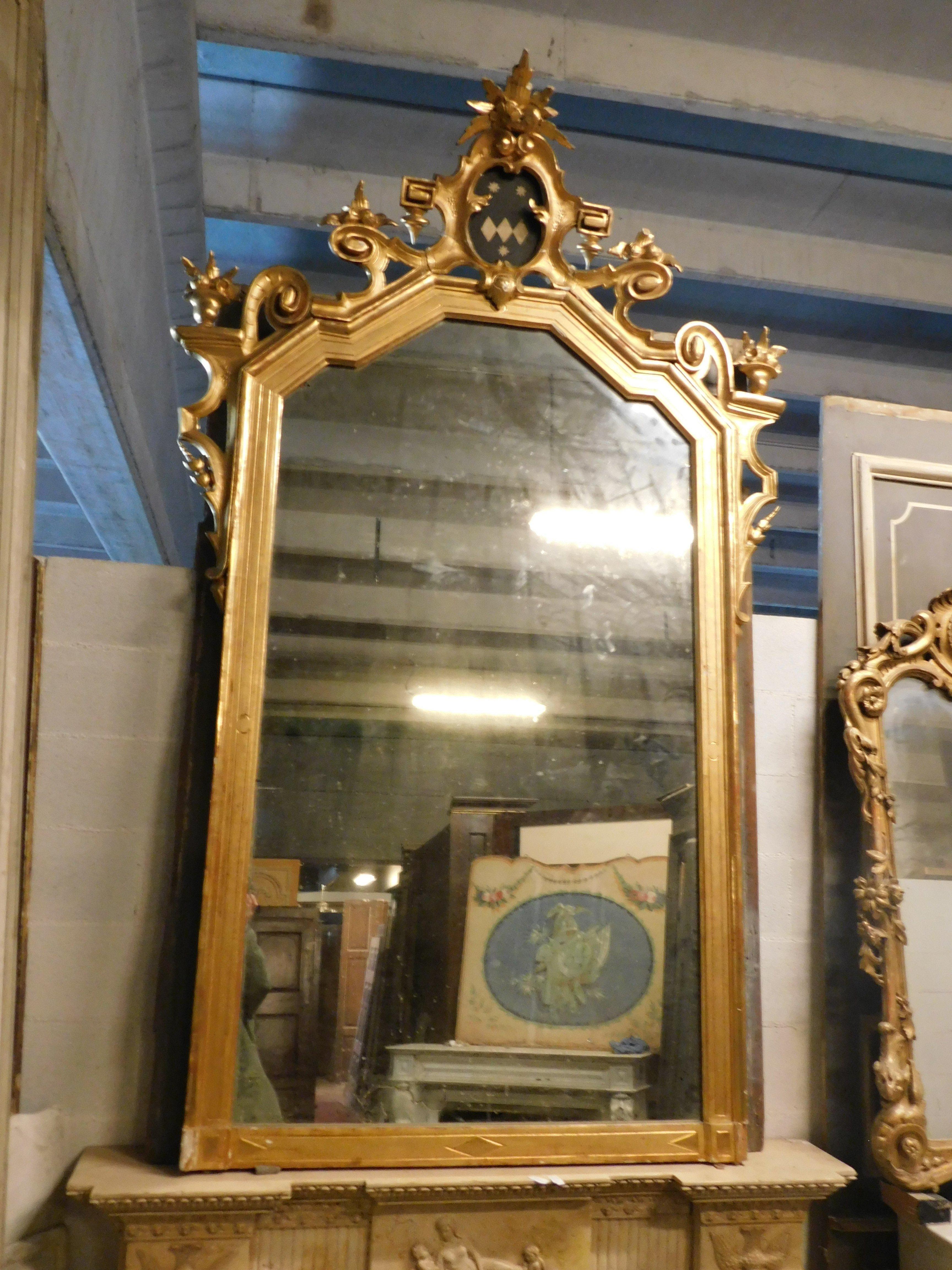 Antique and Large Mirror in solid gilded and carved wood with a very rich cymatium and centered by a painted coat of arms, original from the 19th century, Originating from a large noble palace in Naples.
Measurements cm w 150 x H 245, ideal if