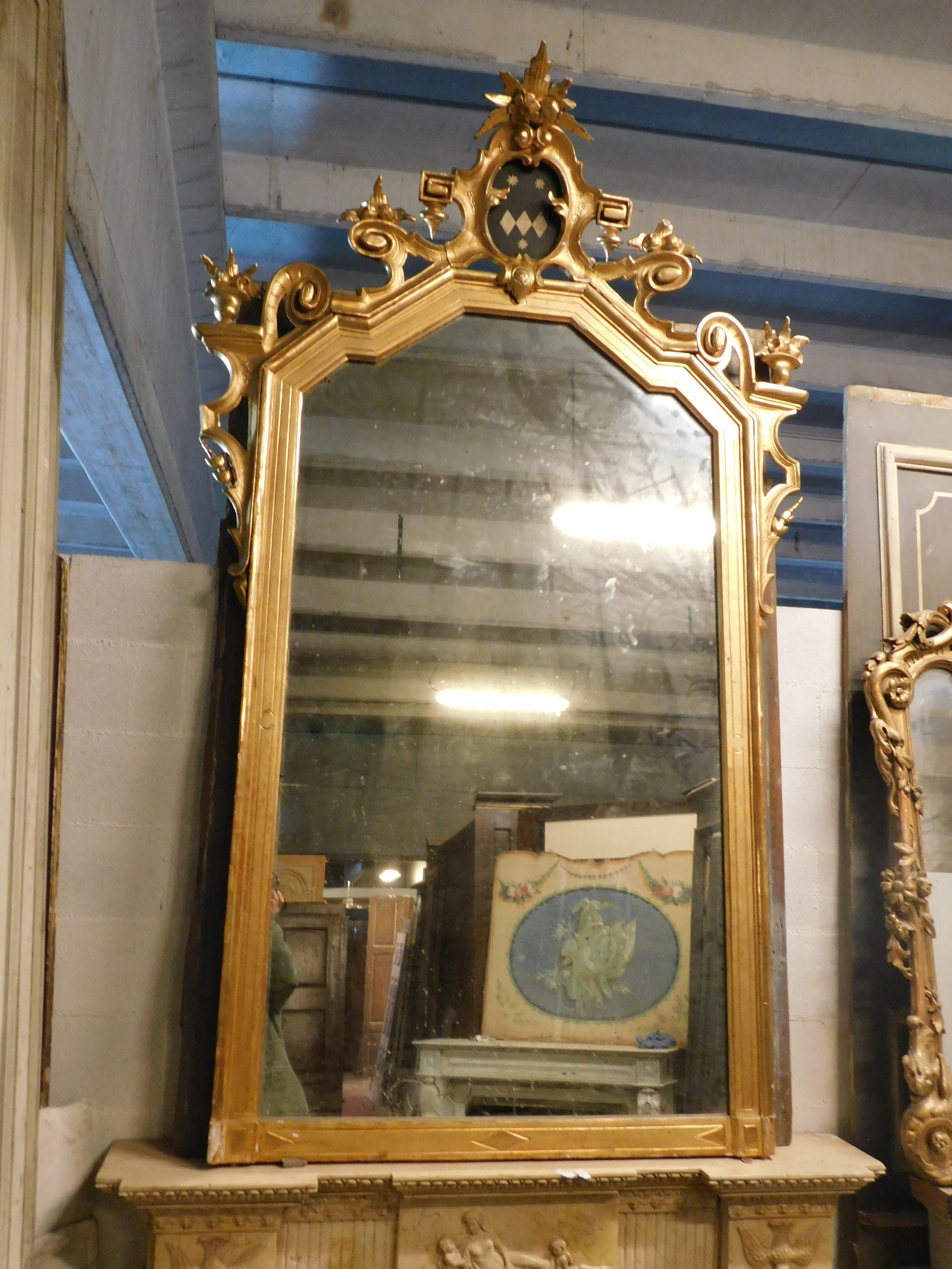 Italian Large gilded wooden mirror with carved top centered by a coat of arms, Italy For Sale