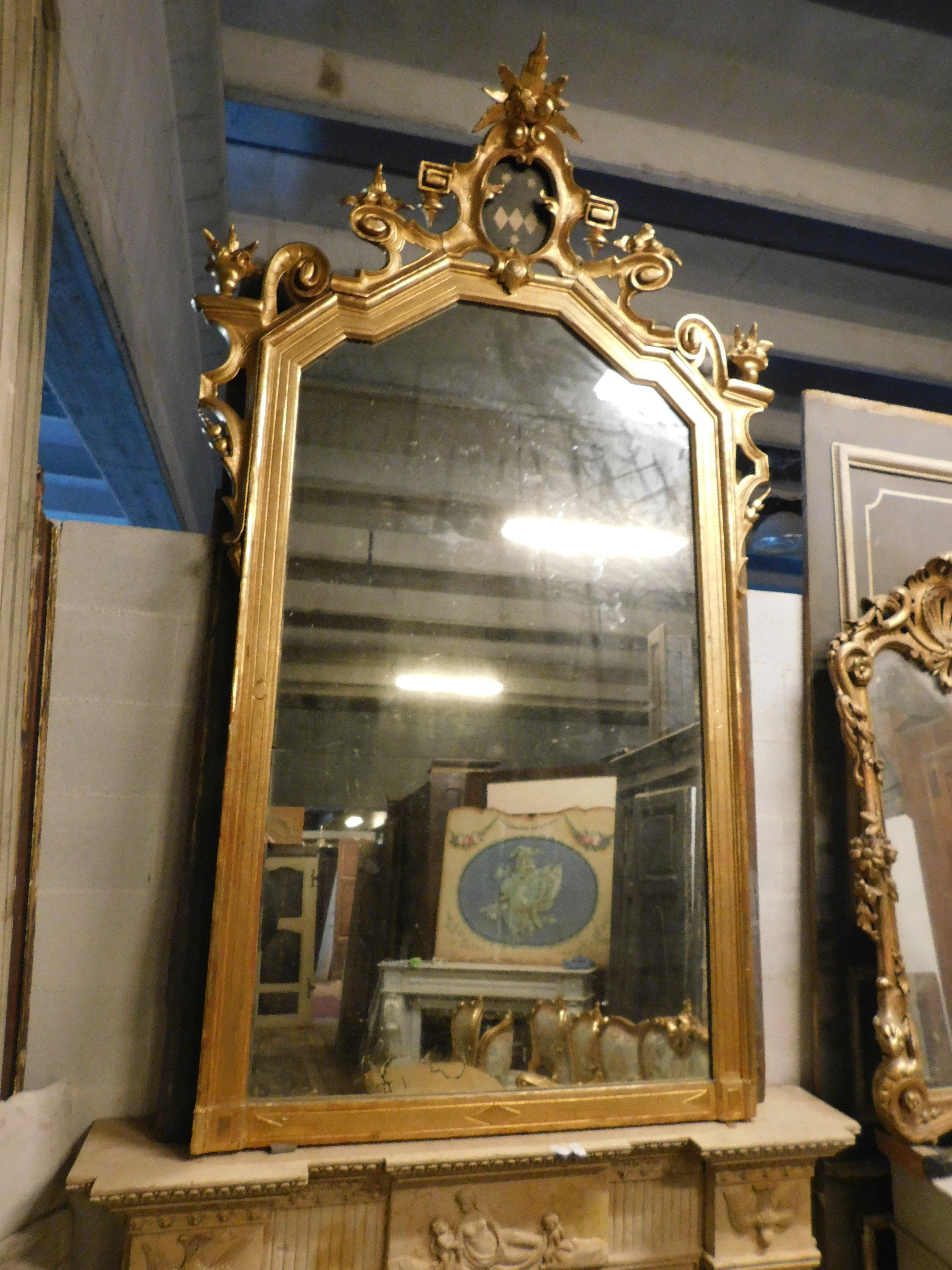 Carved Large gilded wooden mirror with carved top centered by a coat of arms, Italy For Sale