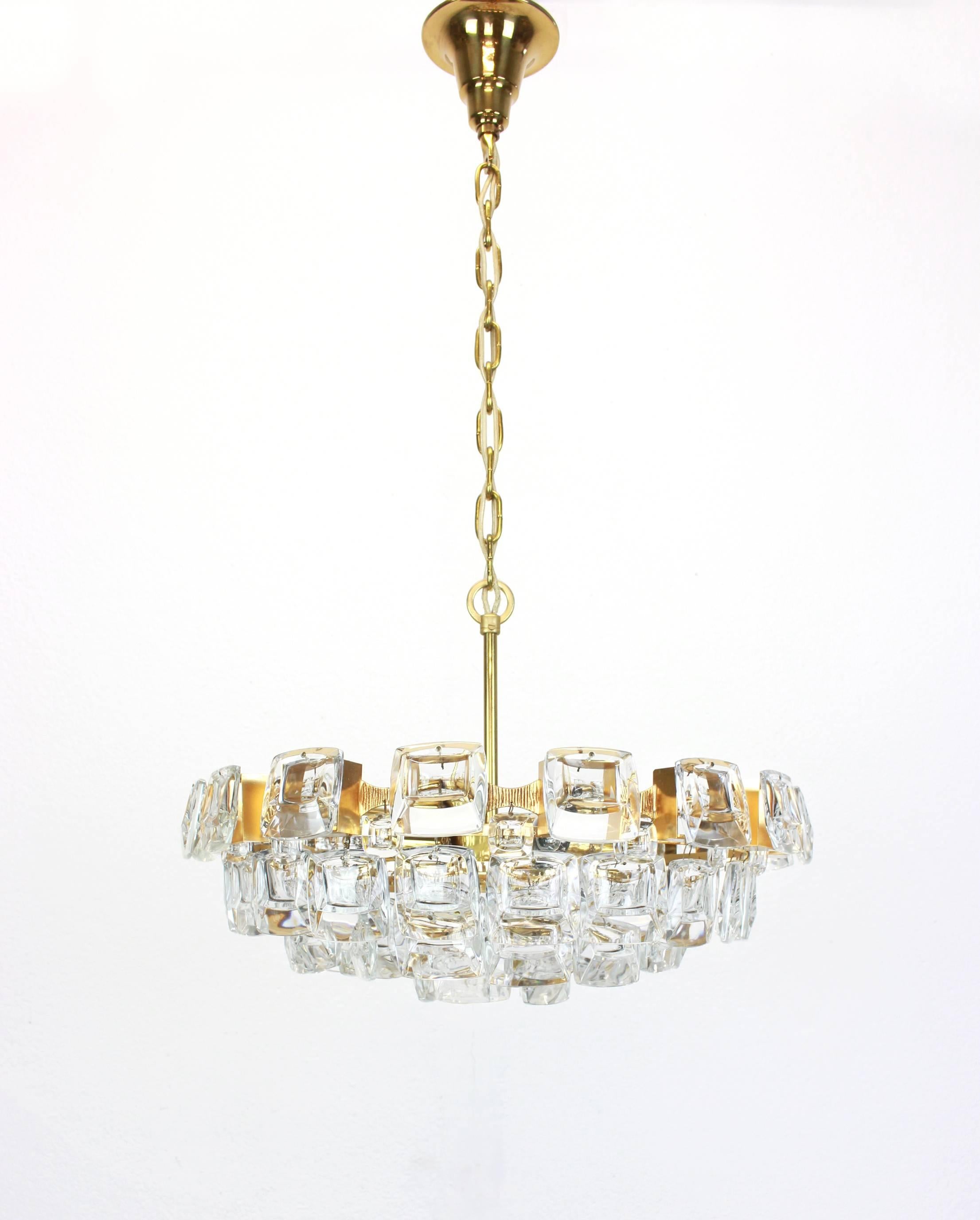 A stunning chandelier by Palwa (Palme and Walter), Germany, manufactured in 1960s. It’s composed of jewel-like glass pieces and brass plates with a Brutalist relief.

High quality and in very good condition. Cleaned, well-wired and ready to use.