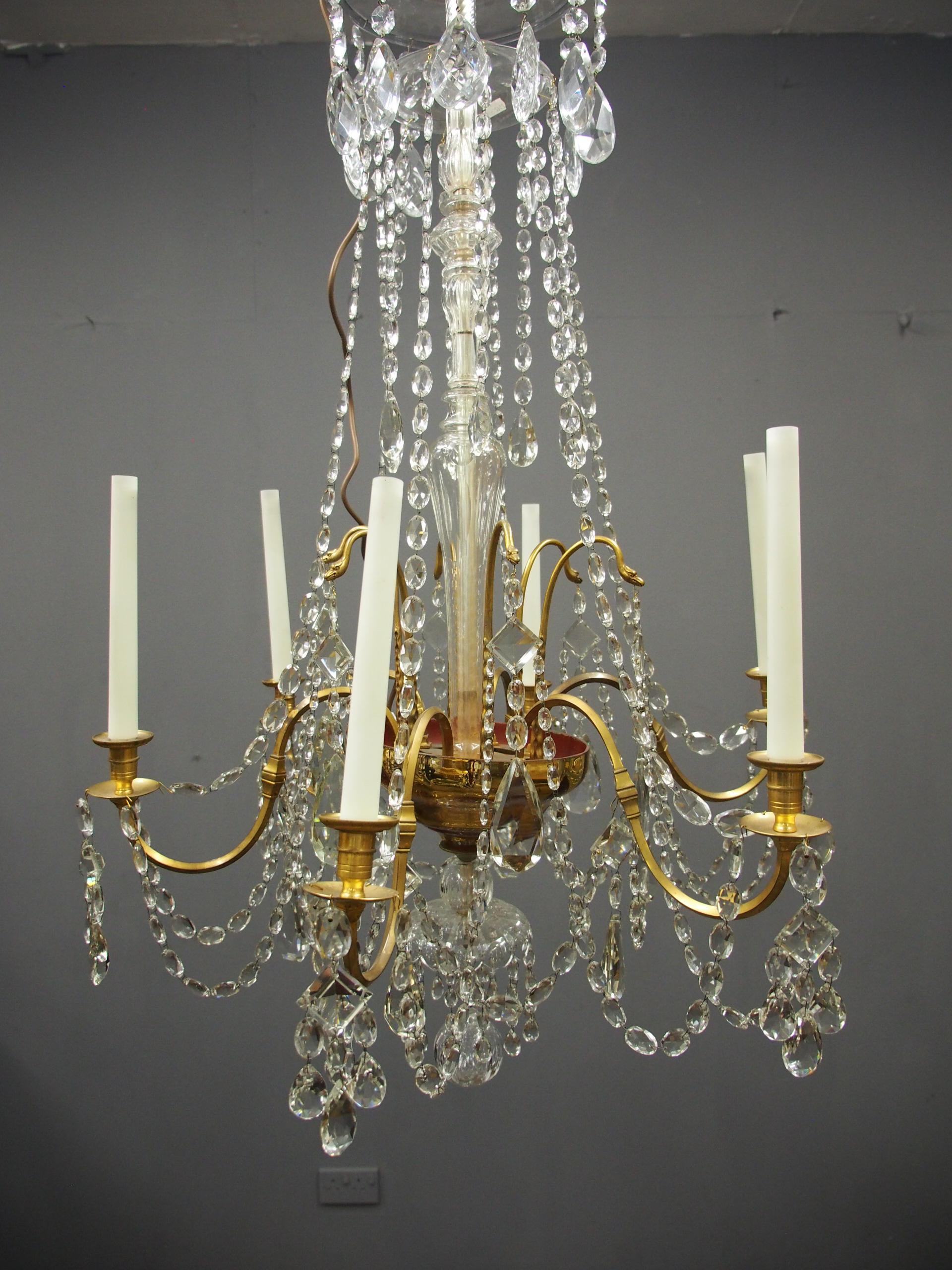 Large gilt brass and glass chandelier. With 6 lights, a shaped glass dome and strings of faceted, beaded glass droplets, circa 1950s. There is a glass baluster centre and each candleholder has been extended with faux handles.



 