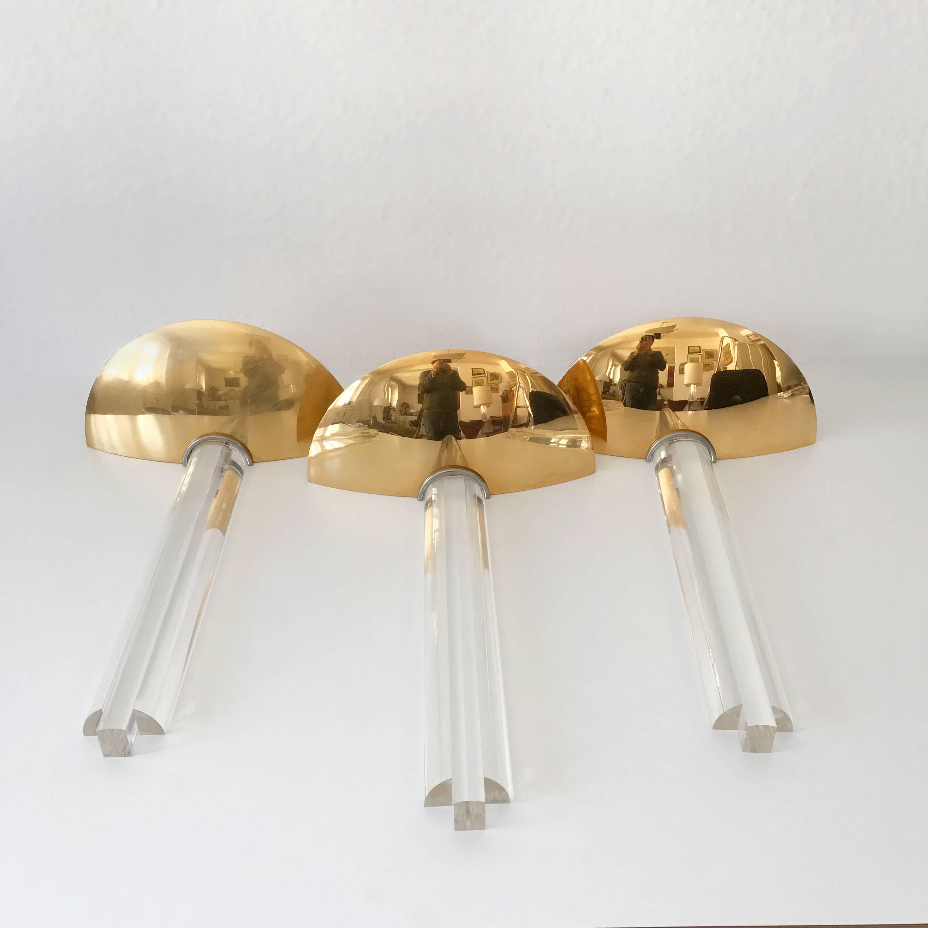 Exceptional set of three Hollywood Regency sconces or wall lamps. Designed and manufactured probably in 1980s, Italy. 

Executed in brass and Lucite, each lamp needs 2 x halogen bulbs; each max. 75 Watt.

Condition:
Good  original vintage condition.
