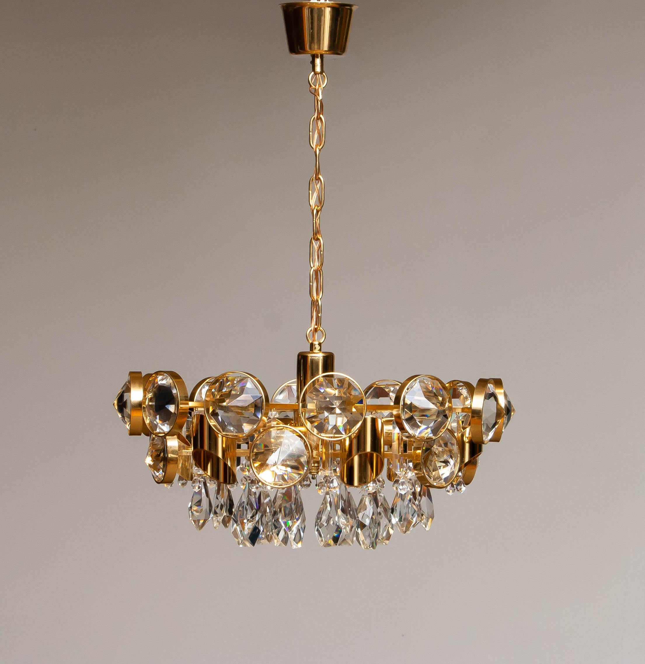 Milieu du XXe siècle Grand lustre en laiton doré rempli de grands cristaux facettés par Ernest Palme en vente