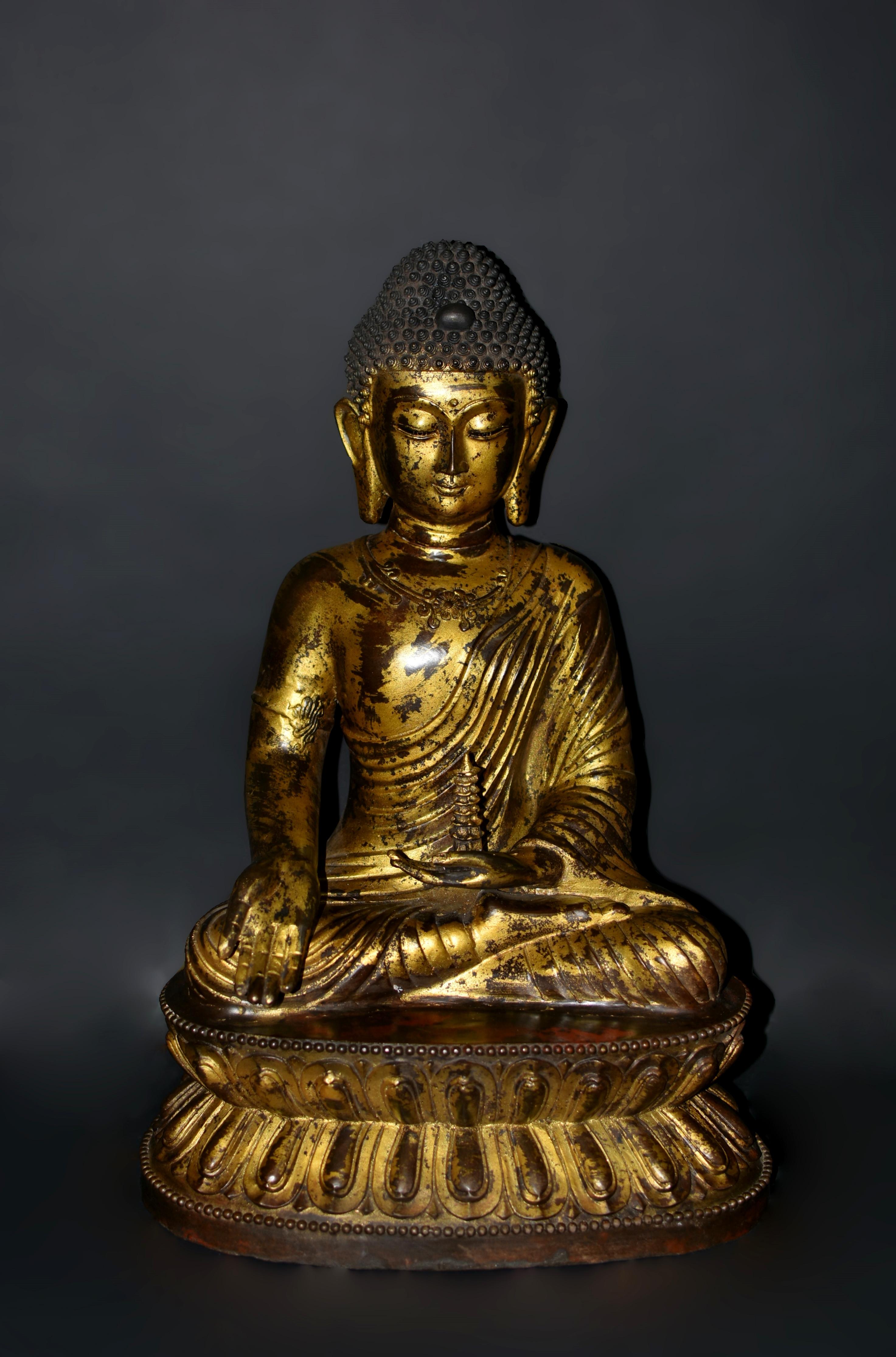 Die prächtige, 31 Pfund schwere Buddha-Statue aus Bronze, die im Stil der Ming-Dynastie gefertigt wurde, besticht durch ihre zeitlose Schönheit und ruhige Präsenz. Die Statue stellt den jungen Shakyamuni dar und strahlt mit ihren niedergeschlagenen