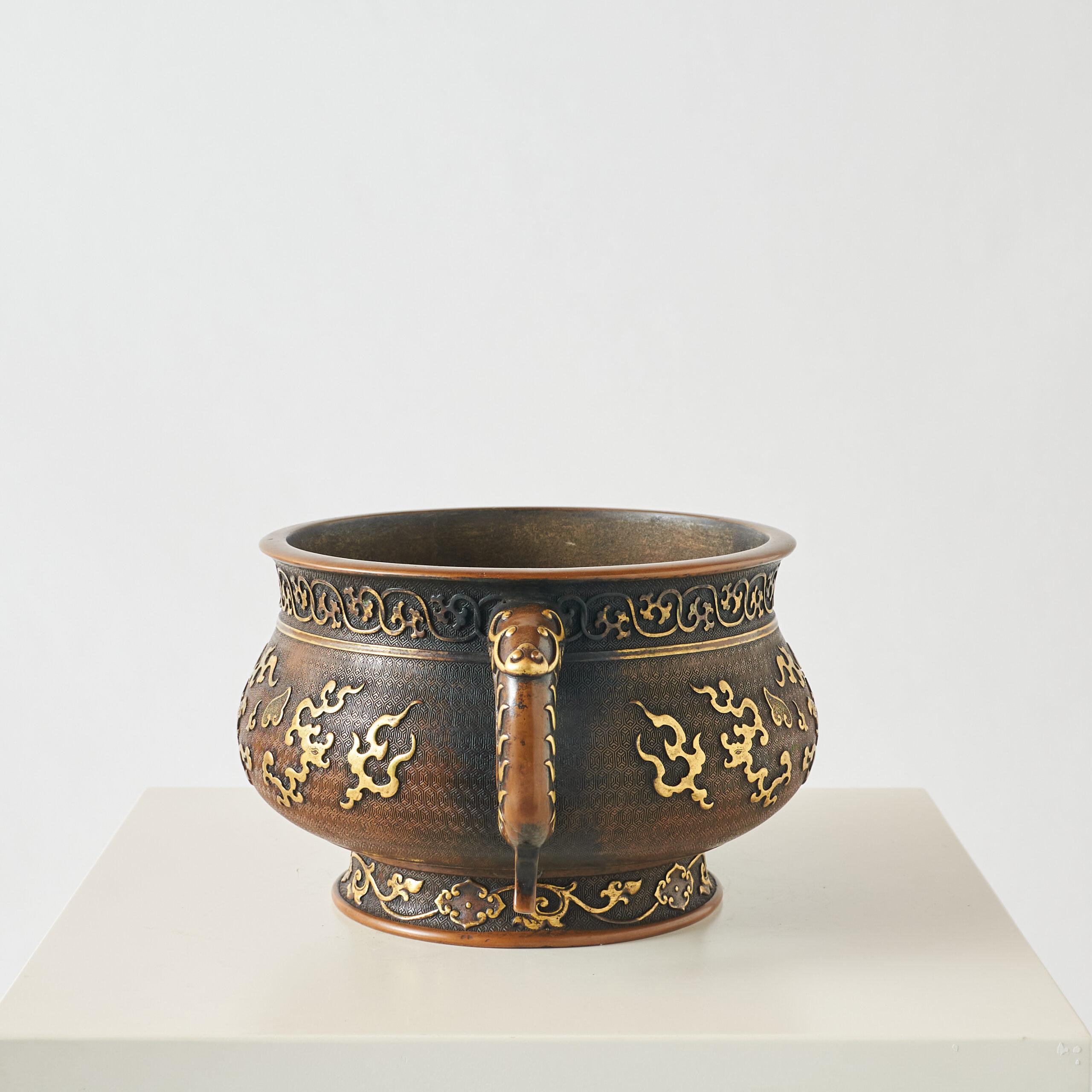 A Large Gilt Bronze Censer.

A large, gilt, bronze censer with twin handles and adorned with an intricate, raised pattern.
Stampled on base.

Additional information:
Dimensions: Height: 6.25″, Width: 13″, Depth: 9″