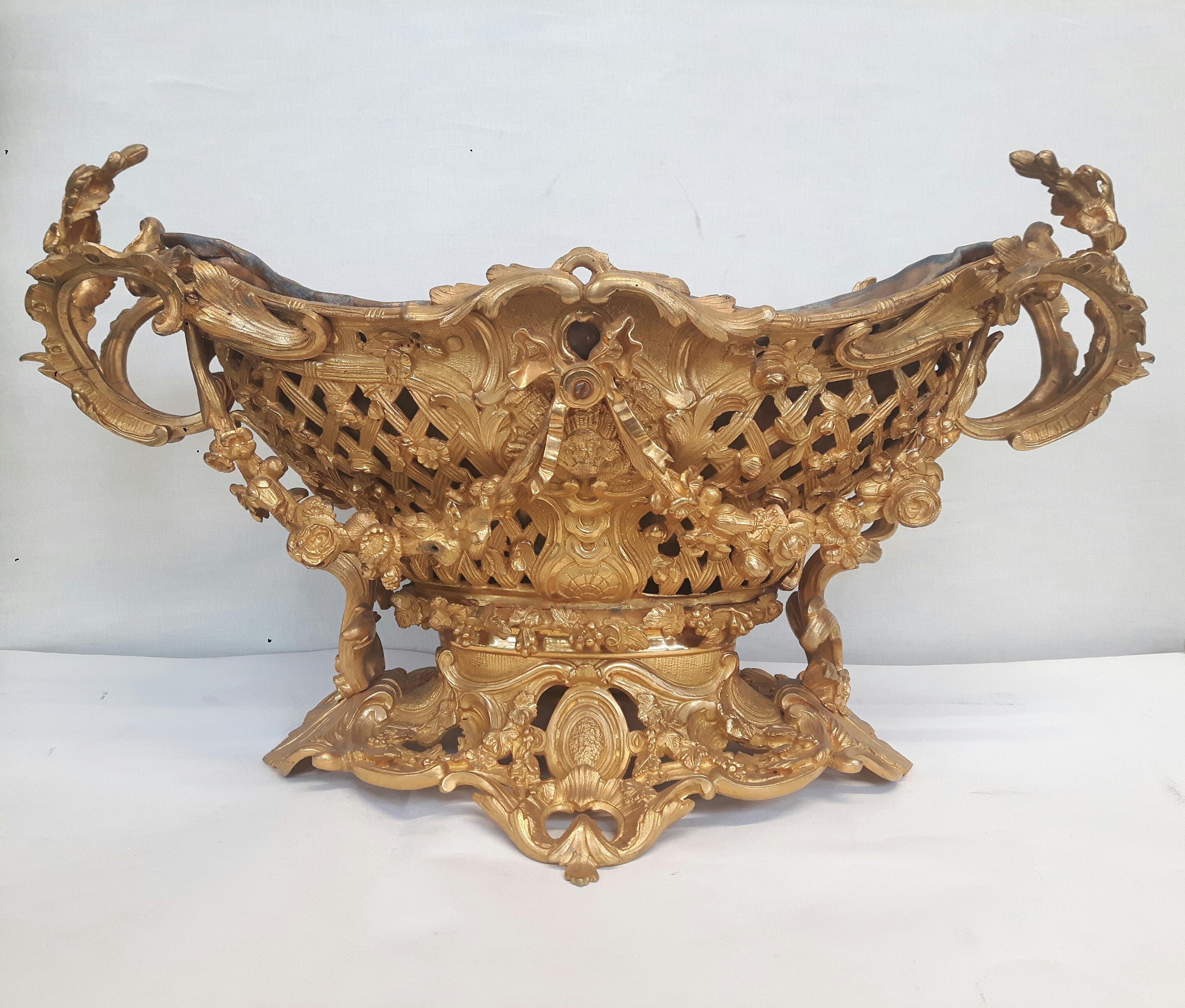 grand centre de table en bronze doré dans le Teste Rococo, vers 1850, estampillé : H.Picard : forme marquise réticulée en vannerie, anses feuillagées, guirlandes florales, doublure en plomb amovible.