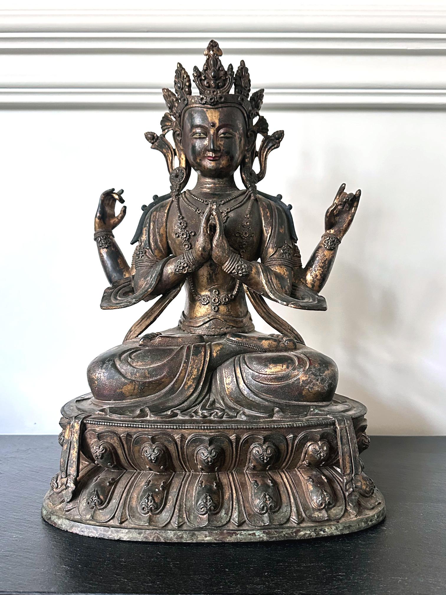 Statue en bronze finement coulée représentant Avalokiteshvara dans sa forme à quatre bras, avec une surface dorée et polychrome. Le Bodhisattva de la compassion infinie est vénéré dans toutes les sectes bouddhistes comme l'une des divinités les plus