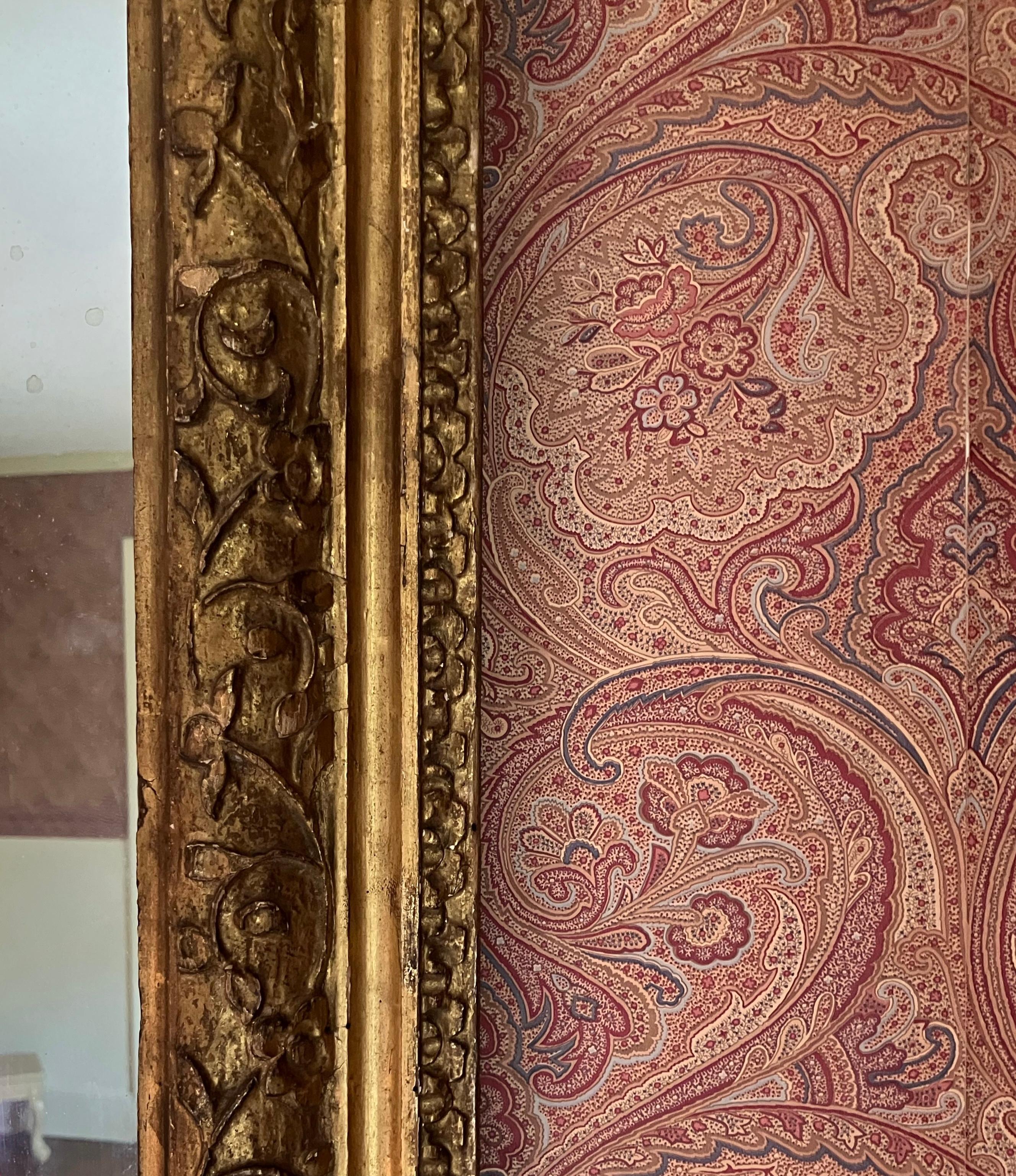Großer vergoldeter geschnitzter Holzspiegel. Ausgedehnter Spiegel aus sanft mercuriertem Glas, eingefasst in einen mit Blättern beschnitzten und vergoldeten Rahmen aus antikem amerikanischen Holz. Vereinigte Staaten, um 1880. 

Abmessungen: 53,25