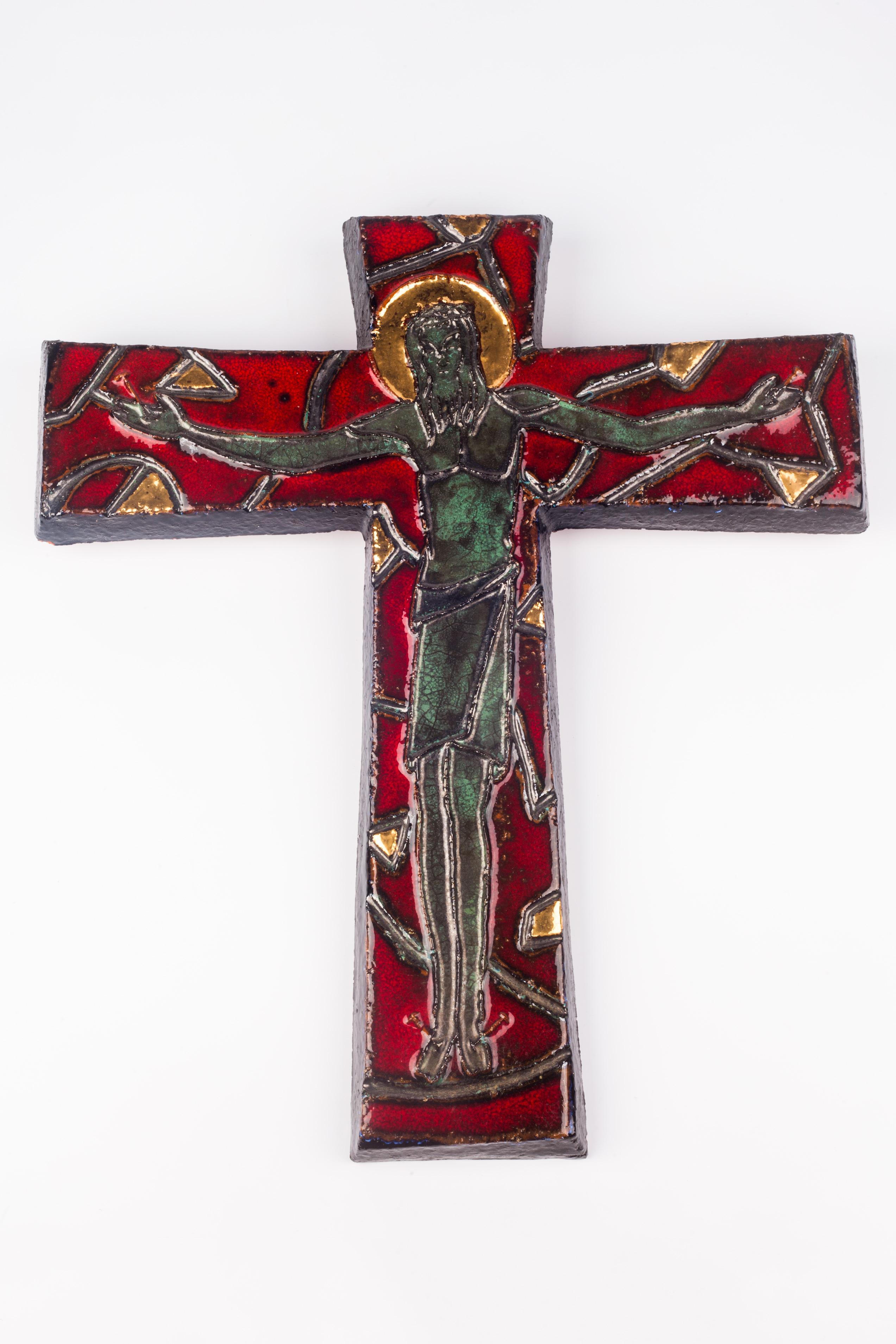 Large, heavy, sixteen inch tall wall crucifix in ceramic, made in the 1980s. Glossy marine green and grey iridescent christ on a deep red cross with stylized green-grey details resembling thorns. Gilt details throughout. 

A one-of-a-kind,