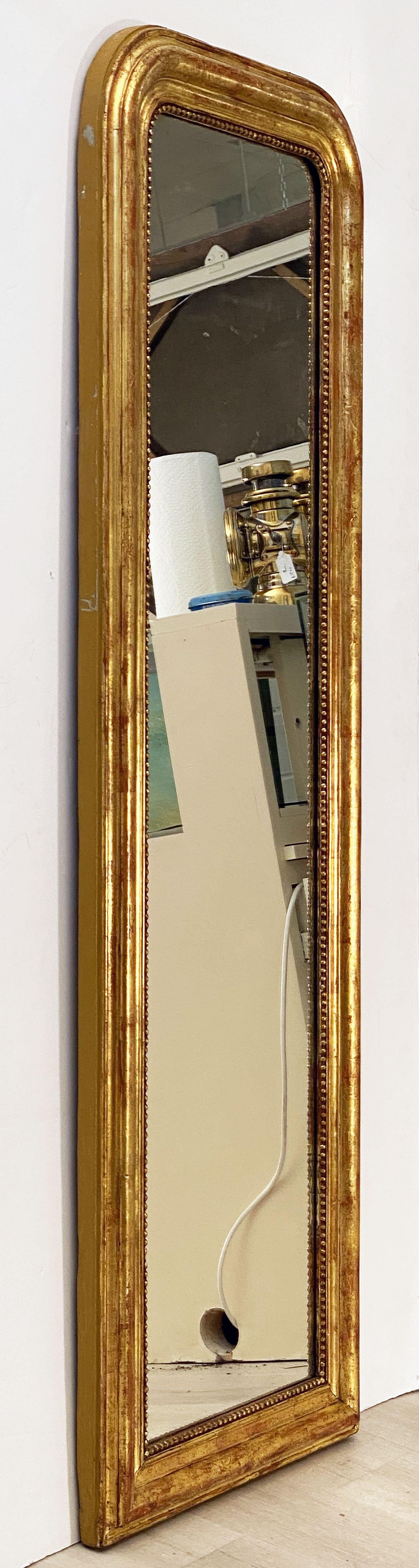 A fine Louis Philippe wall or floor or dressing mirror from France, featuring a tall narrow moulded surround with a beautiful patinated gold-leaf and lovely foliate design.

Dimensions: H 58 1/2 inches x W 19 1/2 inches

Other sizes available in