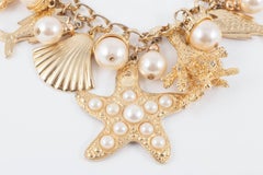 Large gilt metal and paste pearl 'seashell' charm bracelet, USA, 1960s