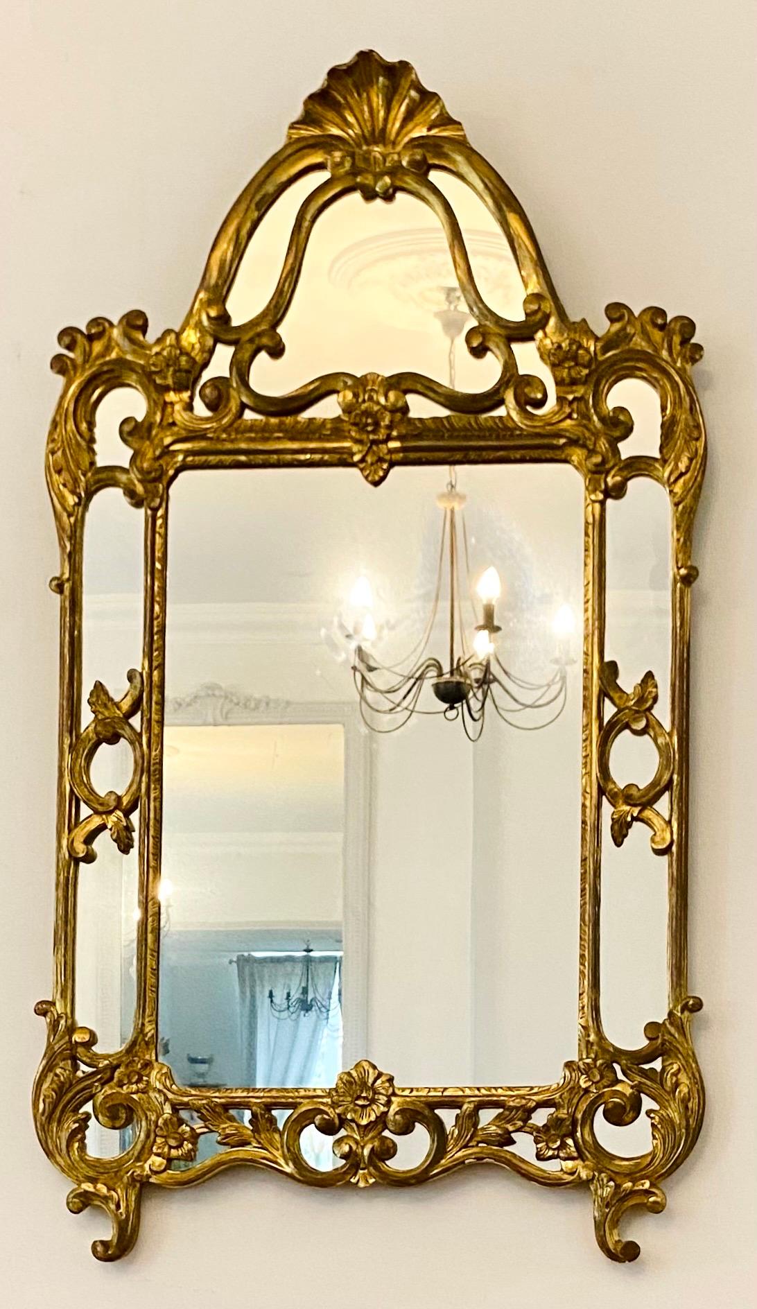 Magnifique miroir à parcloses de style Louis XIV en bois doré.
Dans le style des miroirs italiens, style baroque.
Décor de feuillages et de fleurs entrelacés.
Fronton décoré de coquillages.
Cadre doublement doré magnifiquement travaillé.
Tous les