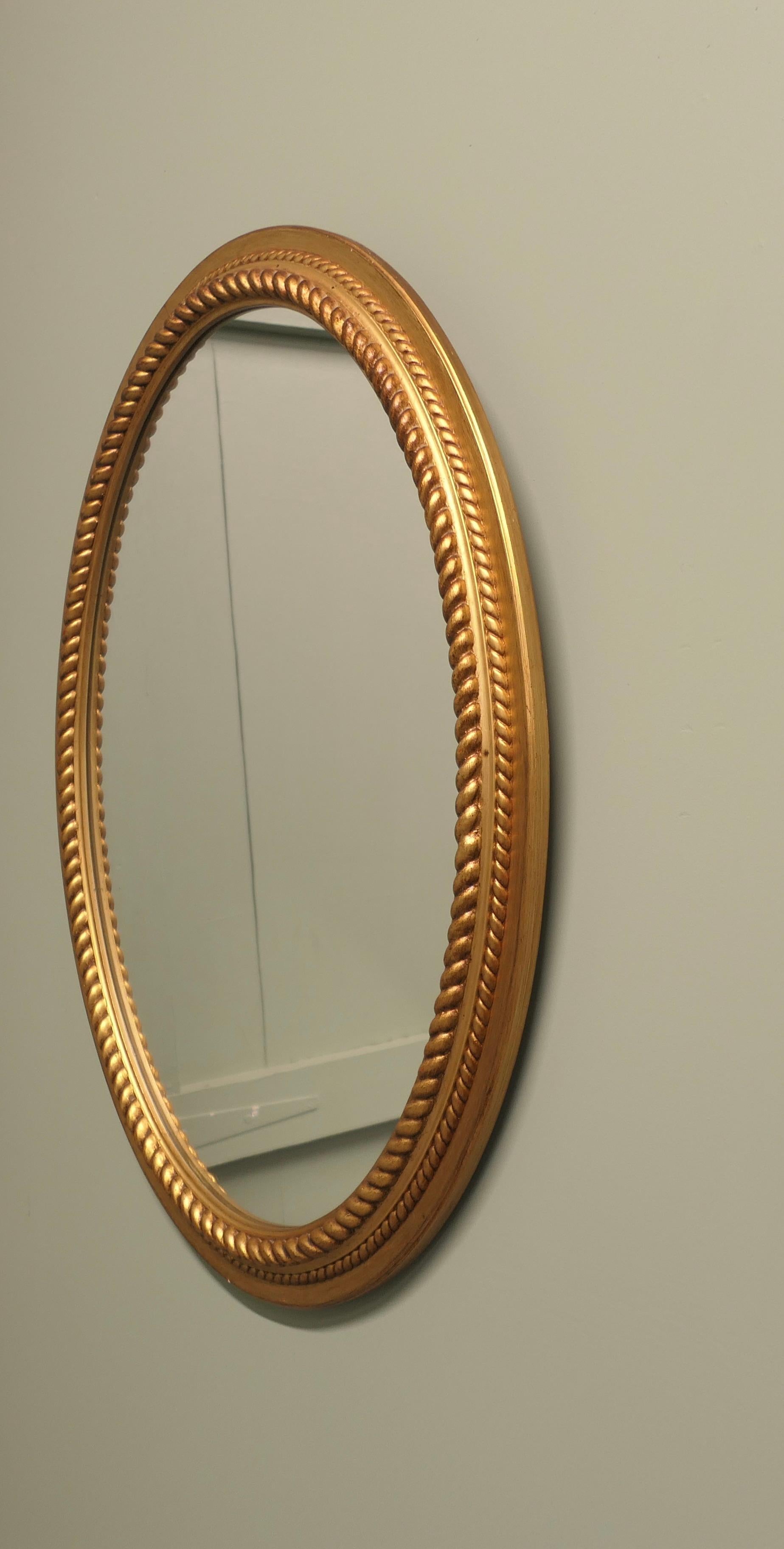 Milieu du XXe siècle Grand miroir ovale doré avec bordure en corde en vente