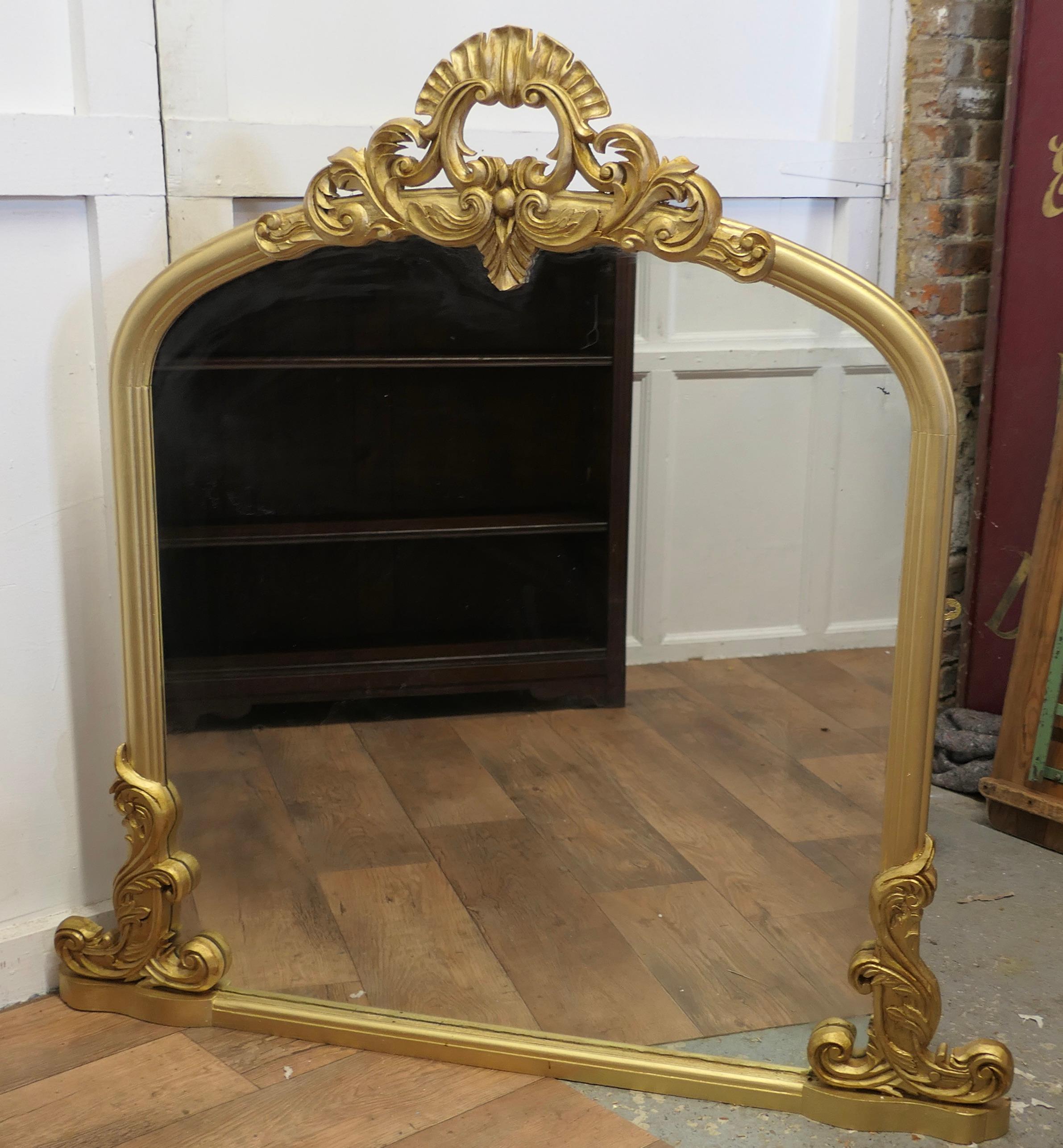 Large Gilt Rococo Style Arched Over Mantle Mirror  

This is a very decorative piece the mirror has a beautiful Rococo Gilt Frame with a 11” high carved central decoration which matches the swags at the base
The large Arched frame is in good sound
