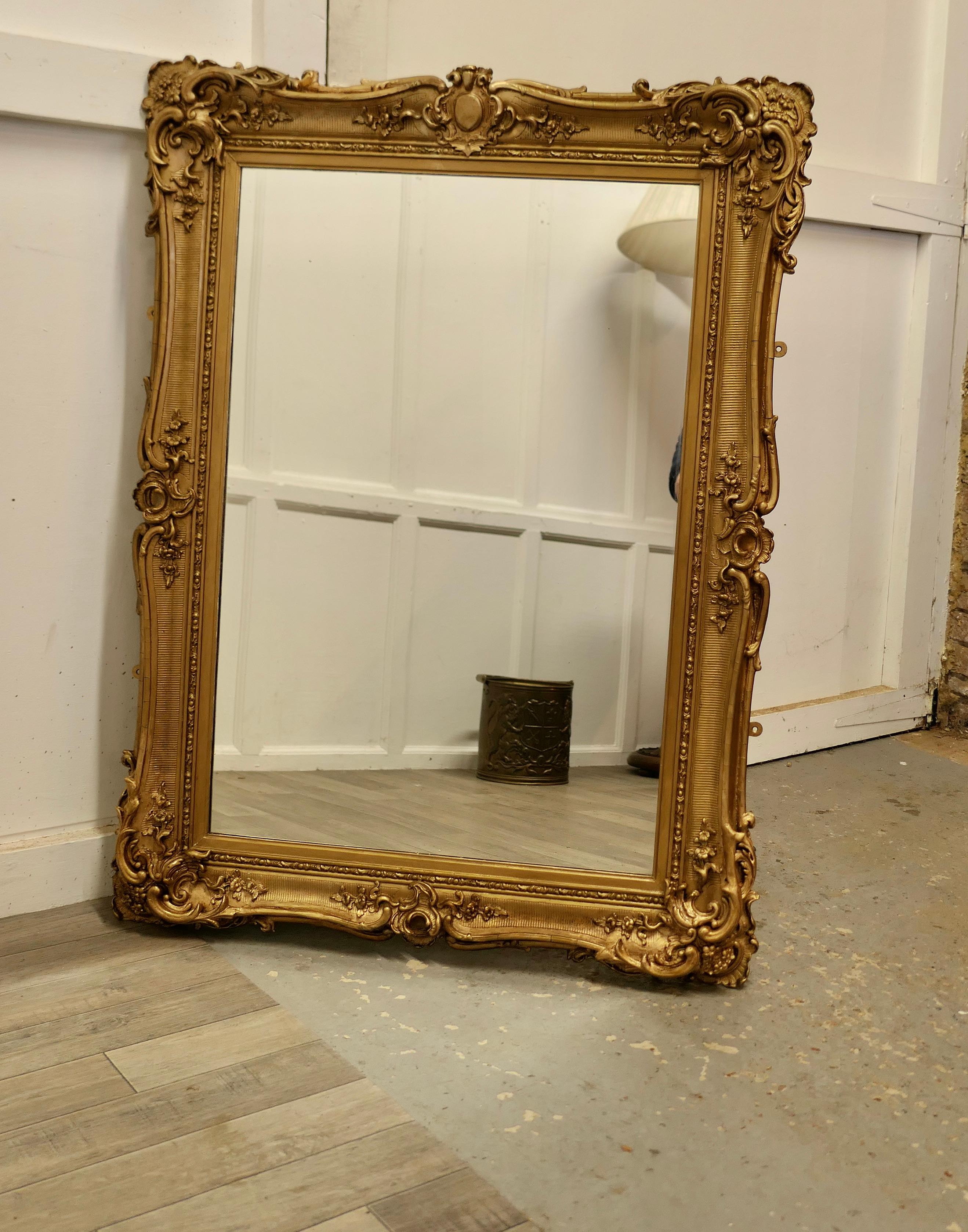 Large gilt rococo wall mirror.

The mirror is in a 5” wide decorate gilt Rococo Style frame 
This is a beautiful and quite elaborate piece, the glass and frame are in good antique condition 
The overall size is 45” high, 34” wide and it is 3”
