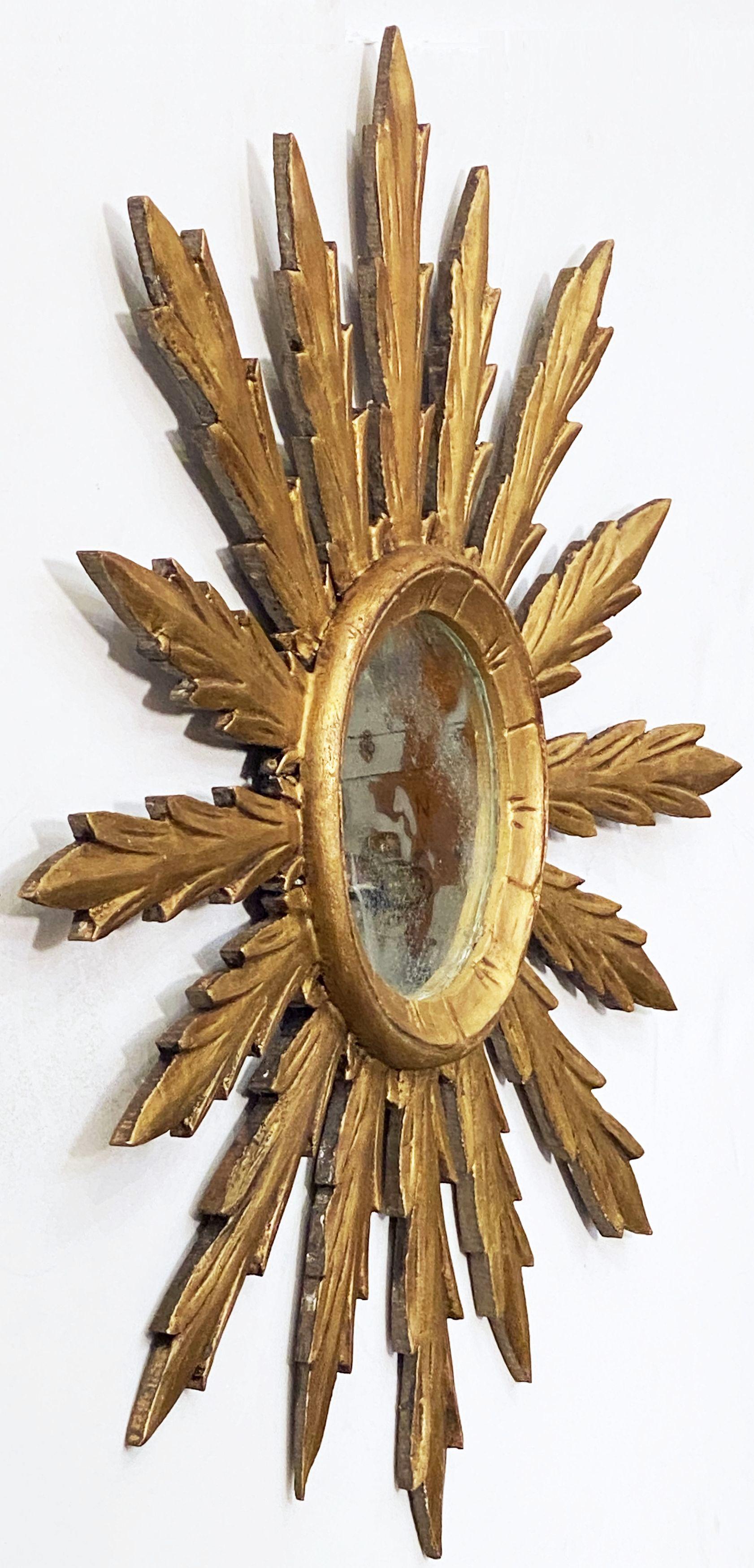 A lovely large Spanish gilt sunburst (or starburst) mirror with original round mirrored glass center in moulded frame.

Diameter of 29 inches.