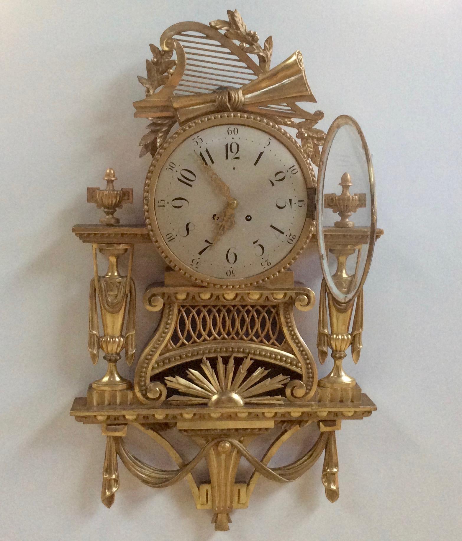 Gilt cartel clock


Painted dial with Roman numerals and pierced gilt hands. 

 Giltwood case with swag decoration, turned finials, surmounted by a harp with starburst decoration below the dial.

Eight day movement by Gustav Becker with silk
