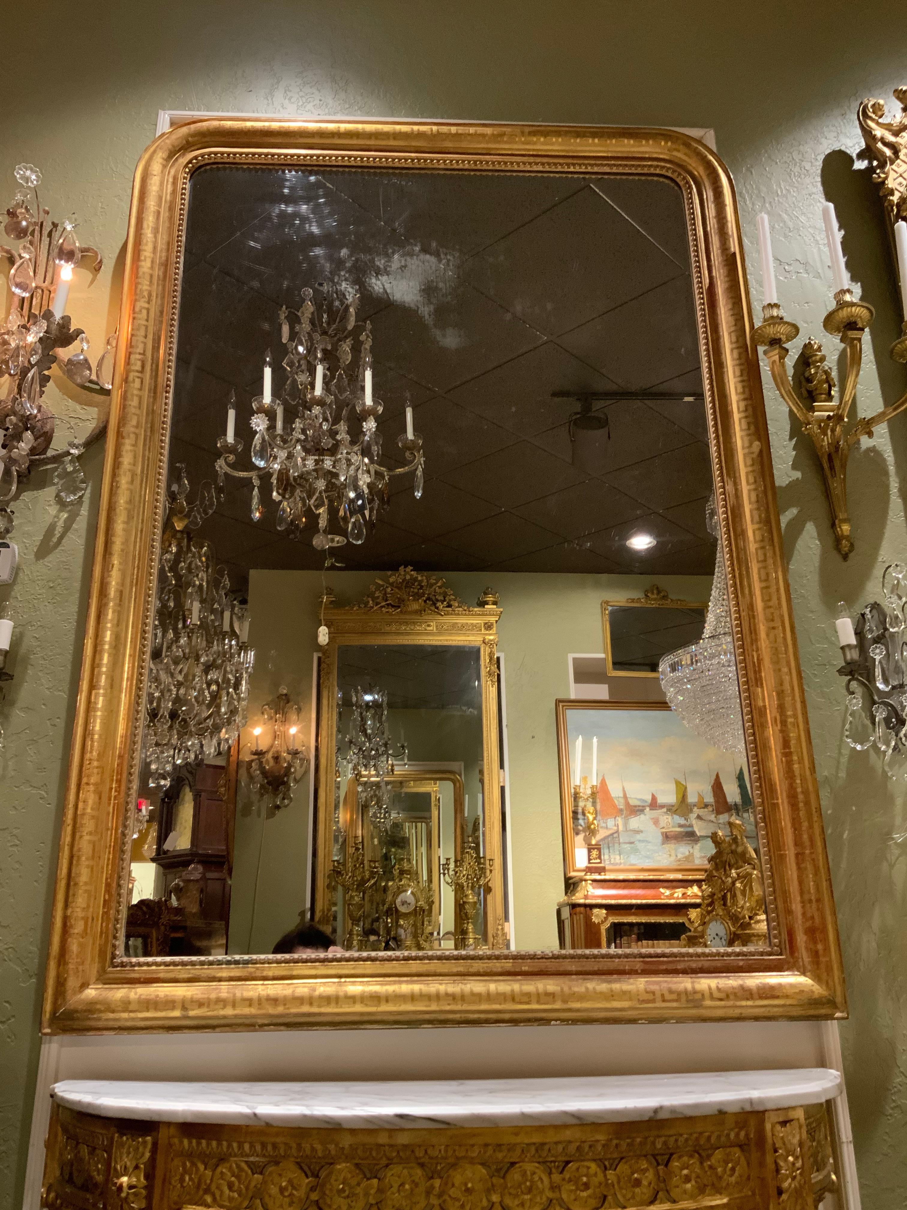 Exceptional Charles X-style mirror in giltwood with a Greek key embossed design.
Beading surrounds the original mirror plate. The red under glow shows through in a
Lovely artistic way.