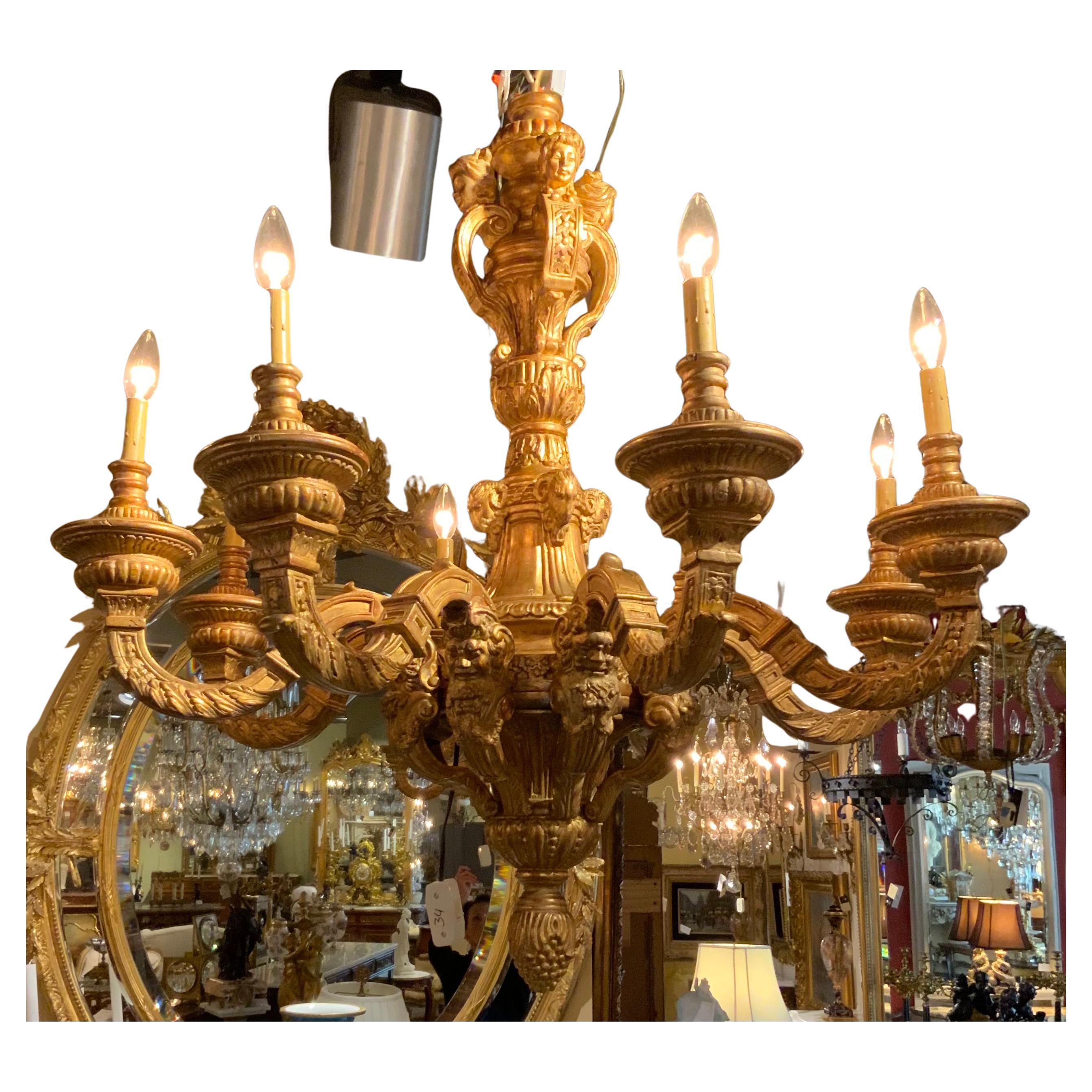 Une sculpture et une dorure exceptionnelles font de ce lustre un objet d'exception. 
Exceptionnellement désirable.  Le style Regence
Il est doté de huit lumières. Il est doté d'un étalon tourné avec des 
Masques, émettant huit bras en volutes,