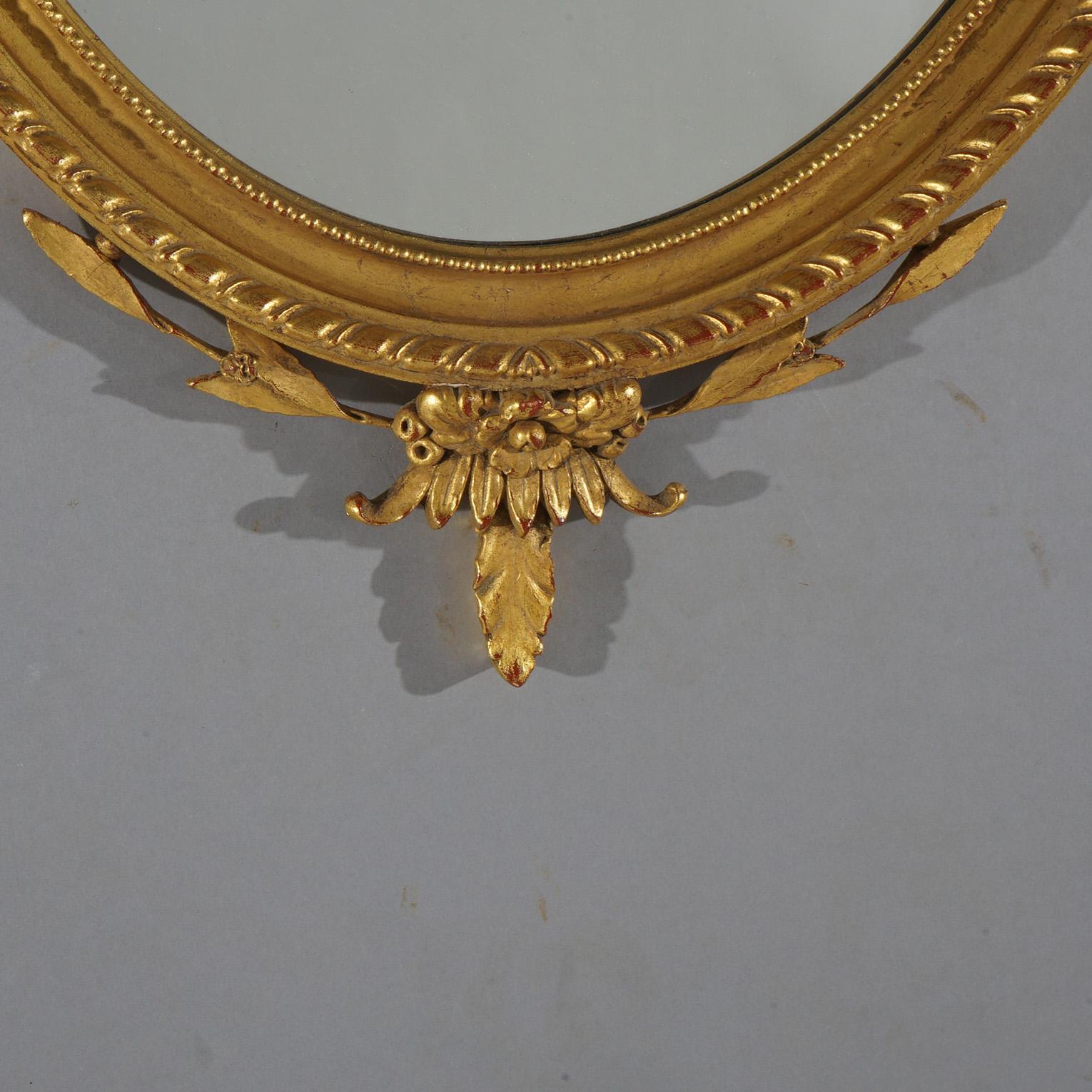 Grande specchio da parete ovale in legno dorato con elementi floreali, fogliame e volute del XX secolo In condizioni buone in vendita a Big Flats, NY