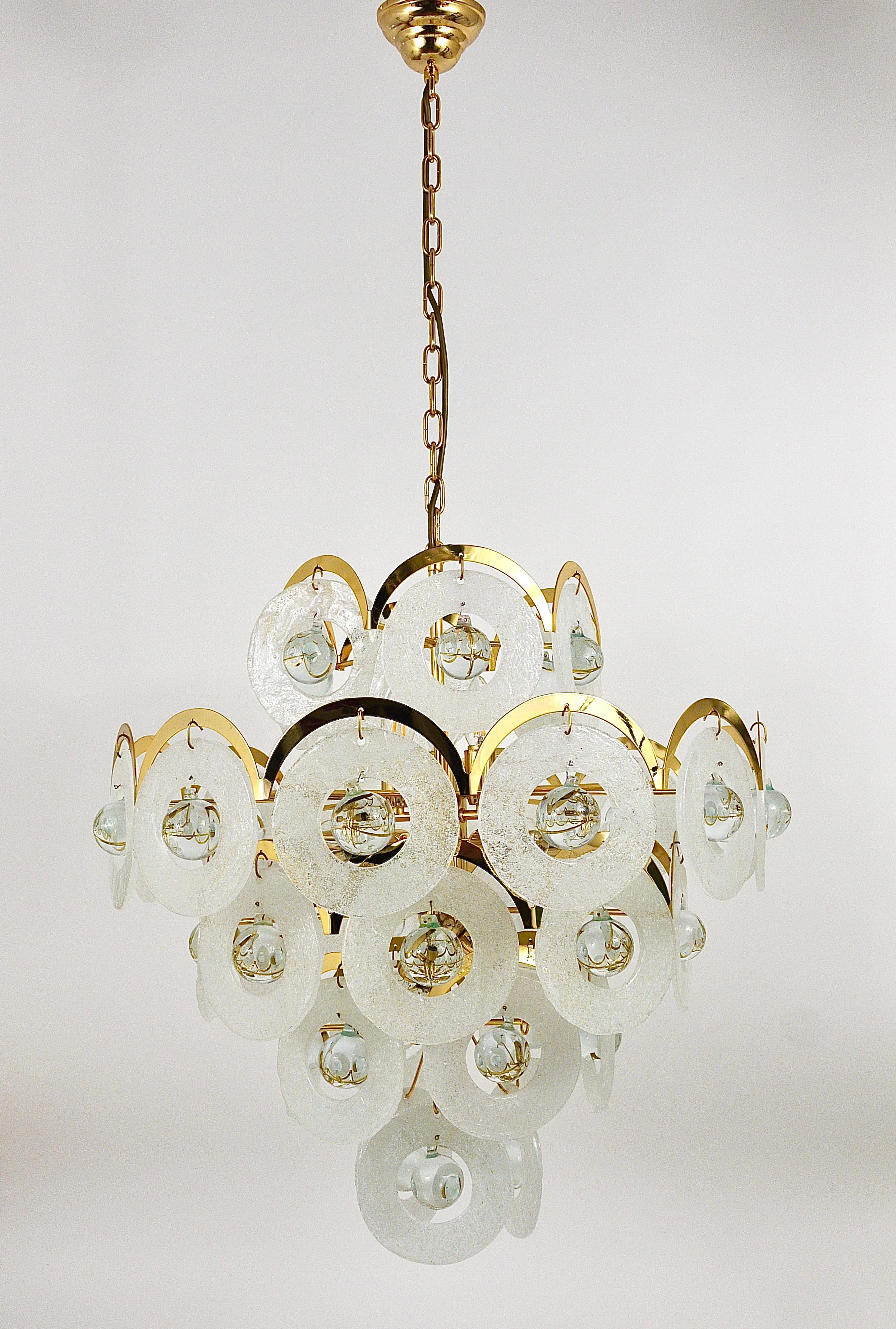 A beautiful and elegant huge round chandelier by Gino Vistosi from the 1970s. A gold-plated arched brass frame with five tiers of handmade ice glass / melting glass rings with clear glass balls in their center. Each disc has a diameter of 6 inches,