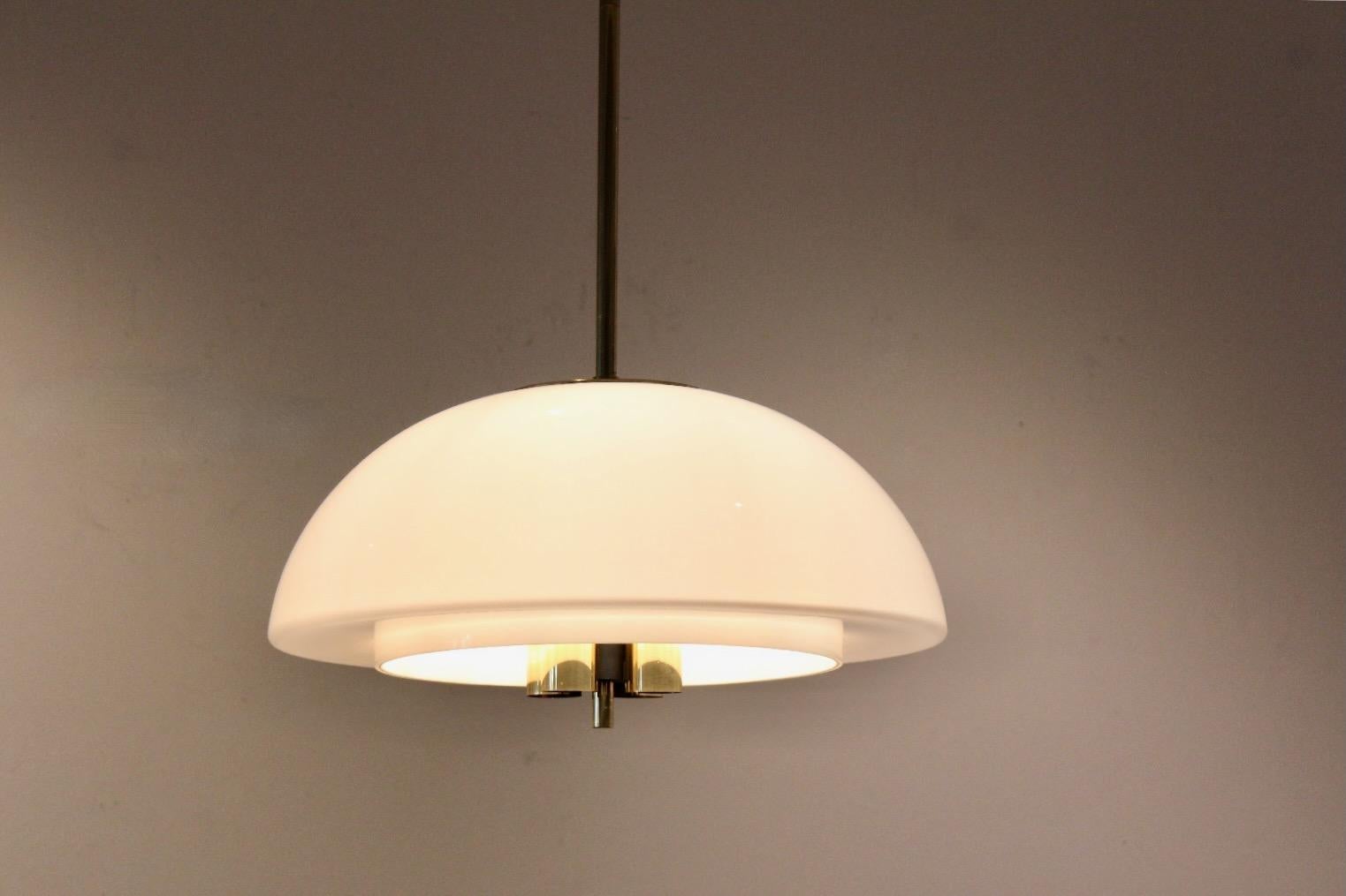 Large Opal glass (hand-made) pendant light, manufactured by Glashütte Limburg, Germany, 1970s. The lamp is made of polished brass with a mouth-blown opaline glass lamp shade that provides a smooth and wonderful large area light. The lamps is in very