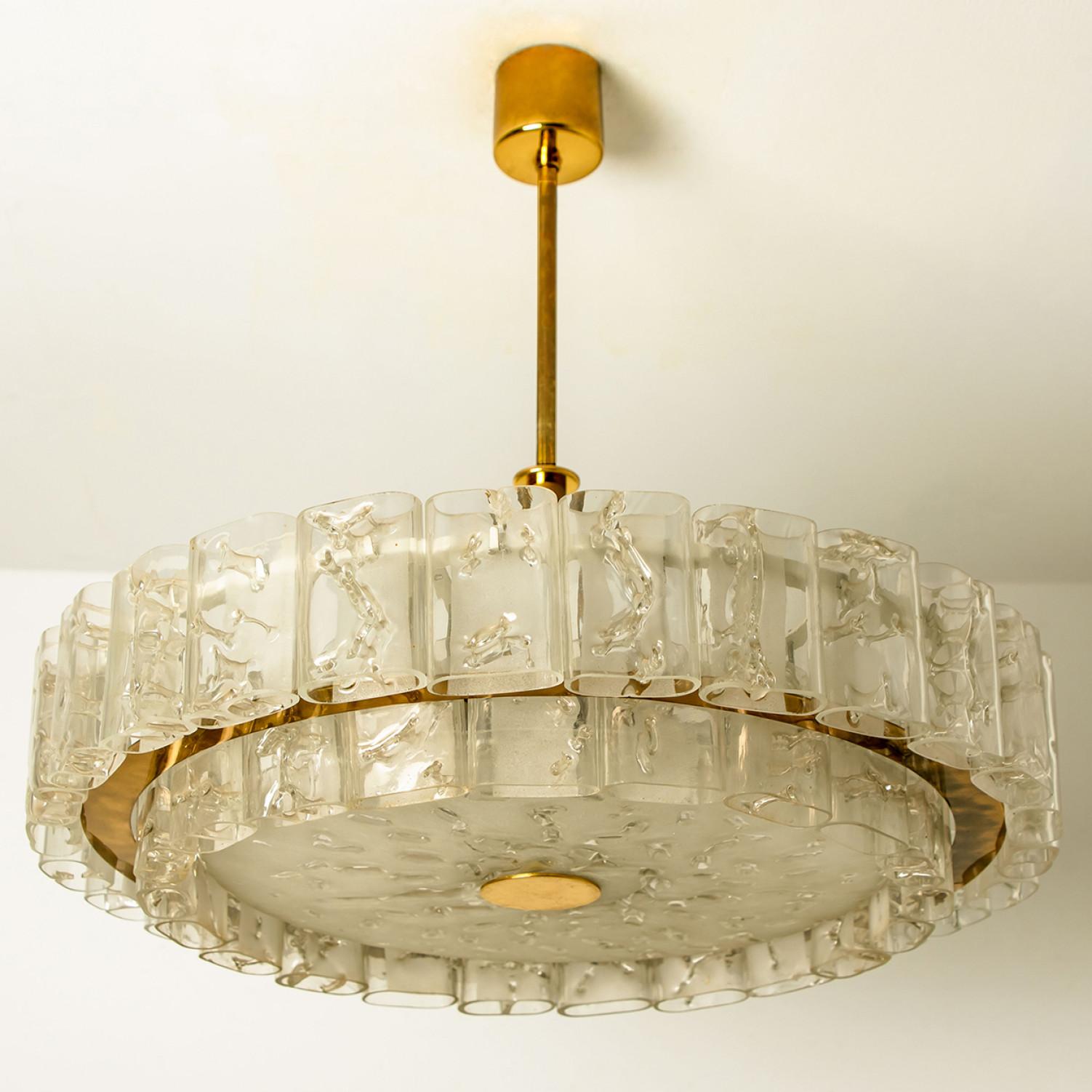 A gorgeous hand blown, oval shaped, glass pendant by Doria Leuchten from the 1970s. The pendant consists of 2 layers with several hand blown textured oval shaped glass tubes mounted on a brass frame arranged in concentric rings.

This pendant is