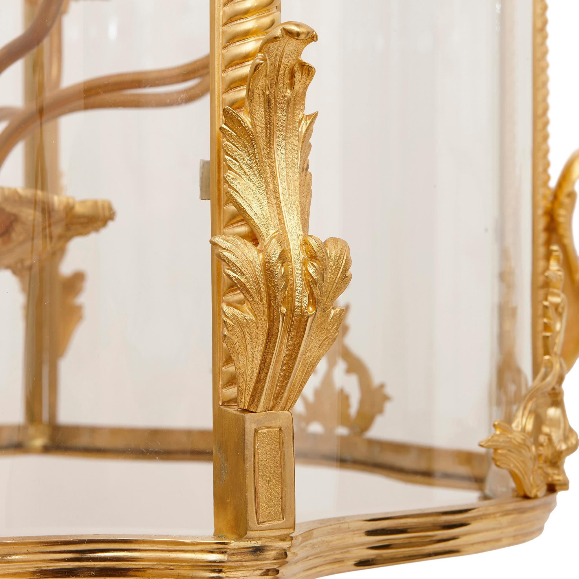 Cette lanterne d'entrée a été délicatement fabriquée en verre et en bronze doré (ormolu). Cette pièce fera merveille dans un grand hall d'entrée, un salon ou une salle à manger. La lumière qu'il produit se reflète sur ses surfaces dorées et