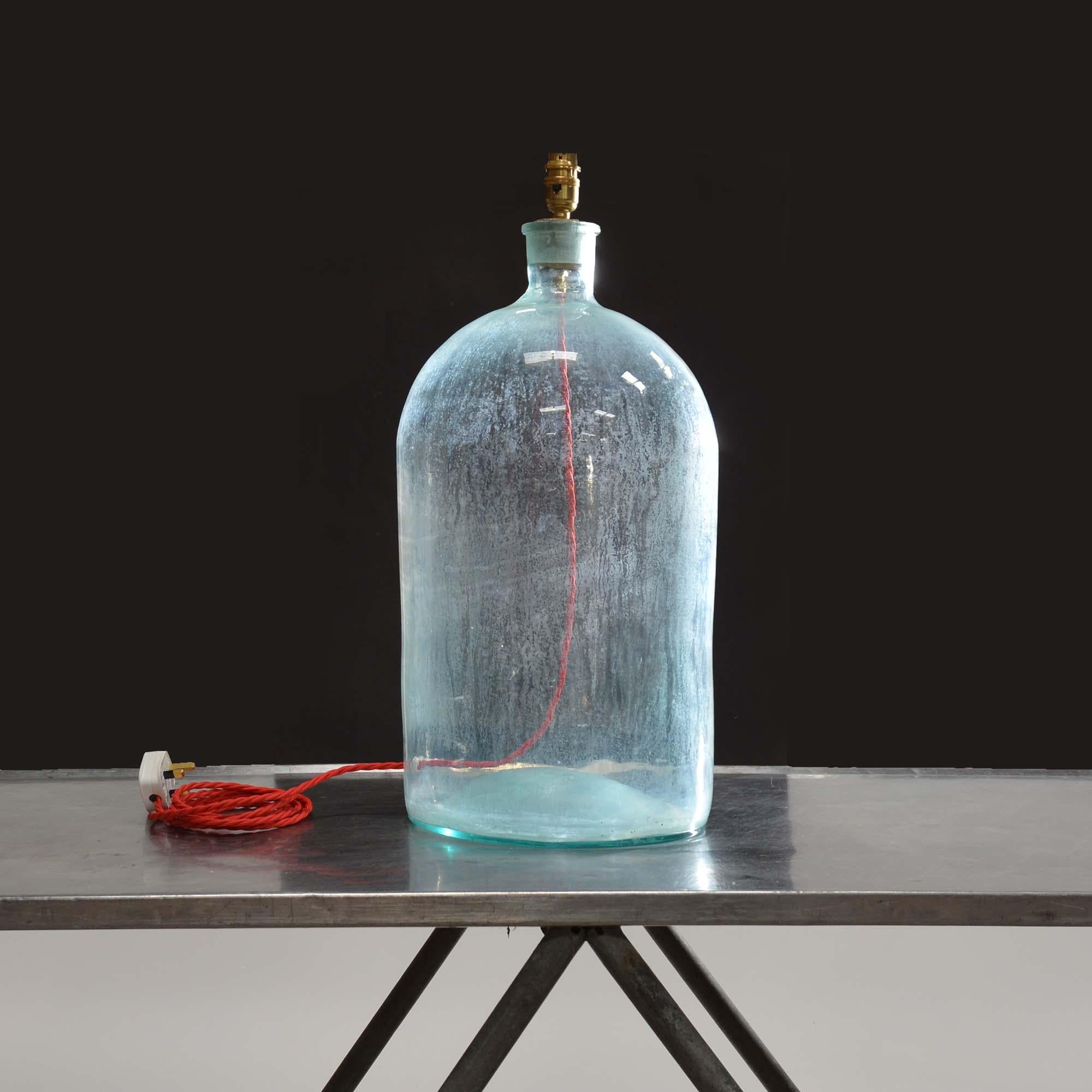 Lampe à grande bouteille en verre
Grande bouteille en verre transparent avec bouchon en liège d'origine, la bouteille est embuée à l'intérieur.  Recâblage avec des fils torsadés tressés rouges et testés PAT.
Britannique, début du 20e siècle.

58cm