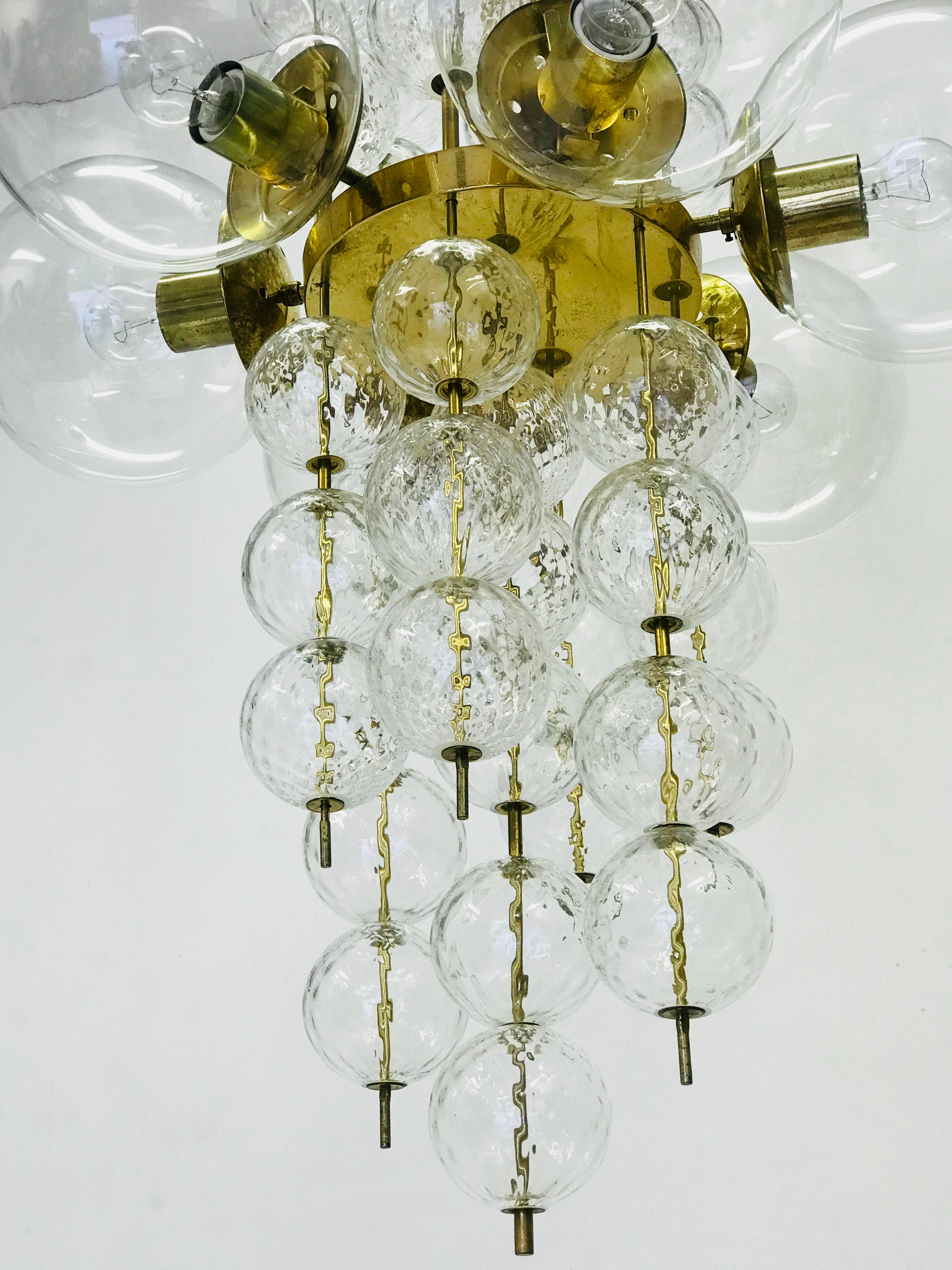 An unique chandelier from the 1965s. The brass construction is completed with the original patina. The glass balls are hand-blown. The conditions is very nice. The chandelier is fitted with ten glass spheres of 22 cm in diameter. Each arm has an