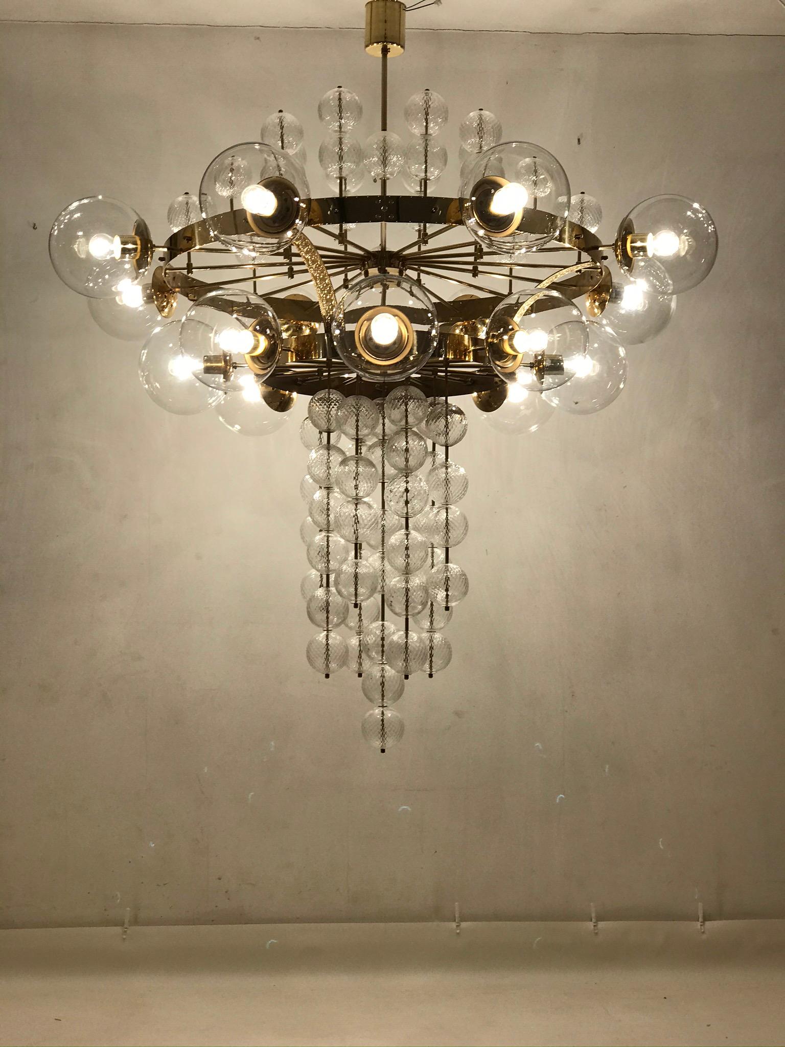 An unique chandelier from the 1965s. The brass construction is completed with the original patina. The chandelier has 16 glass balls which are hand blown. The condition is very nice. The chandelier is fitted with ten glass spheres of 22 cm in