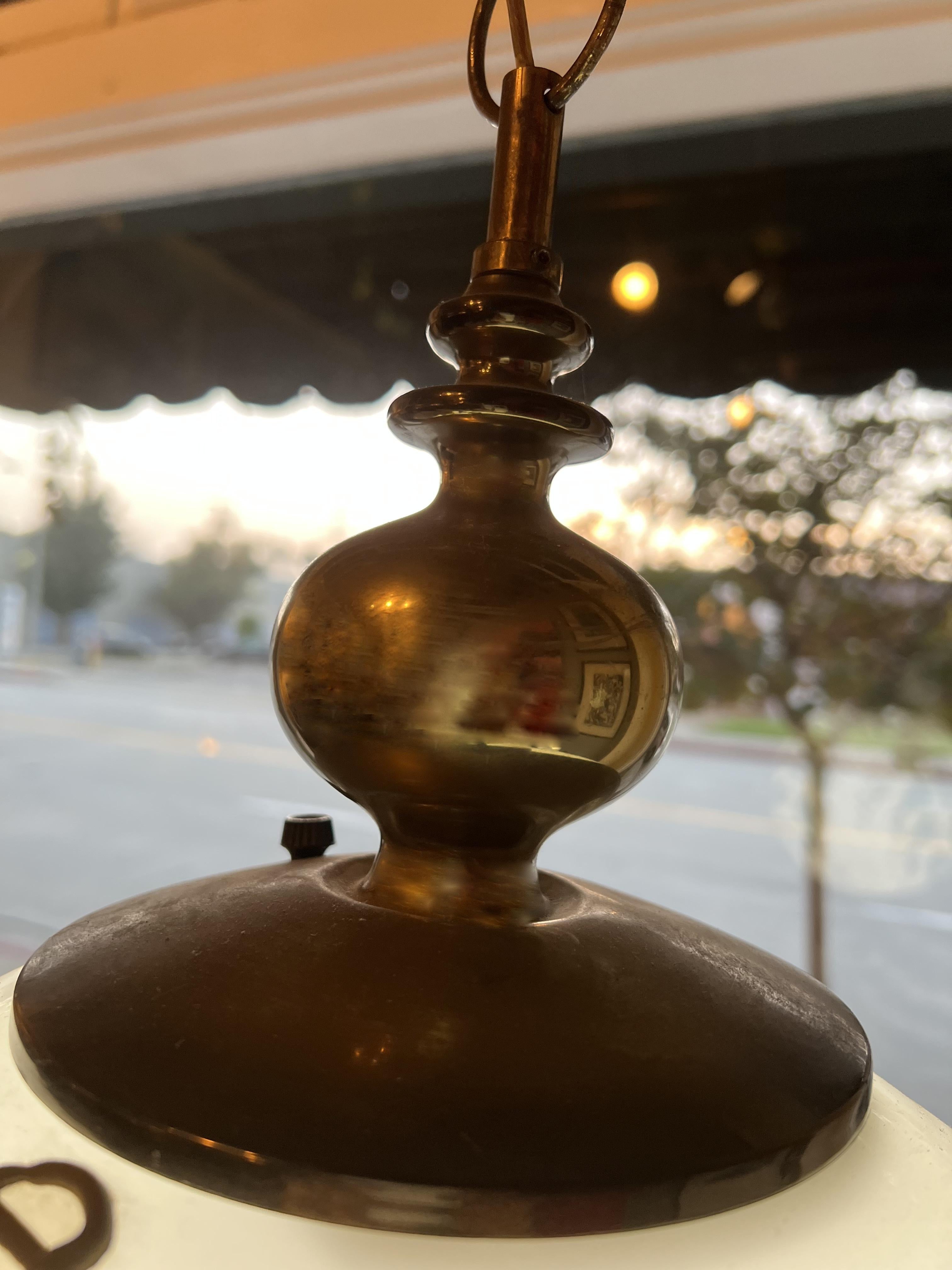 Large flourished glass globe attached to a brass hardware and hanging with a brass chain. The decor is painted on the glass.
The chain is very long but can be cut it to the length you need.