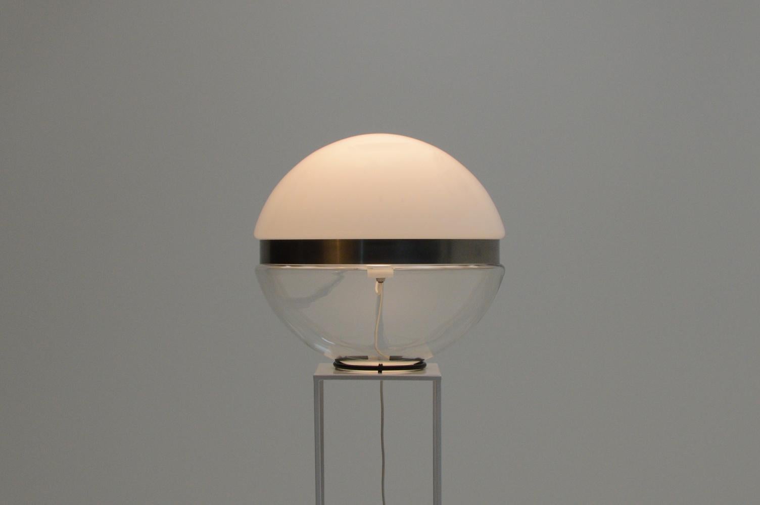 Large glass globe table lamp, 1970s Italy. The globe has a whit glass top, transparent underside and in the middle a brushed steel ring. All stands on a black ring where the wire runs through. The E27 bulb holder floats in the middel of the globe.