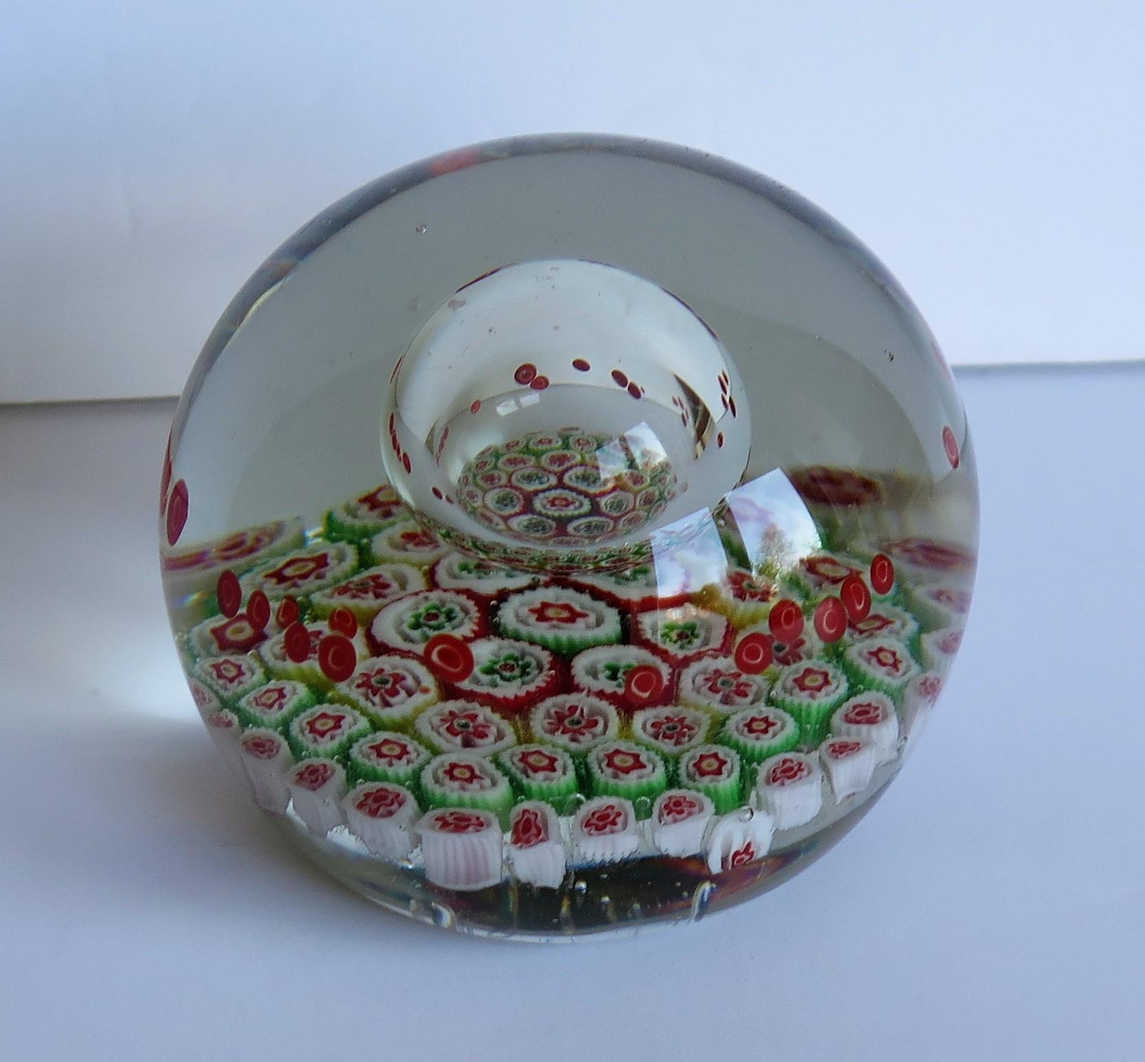 This is a beautiful handmade Millefiori Paperweight with a suspended domed bubble within it which we date to Circa 1900 or possibly earlier. It is heavy with a large diameter of 3.5 inches.

This paperweight is very well made with a Millefiori