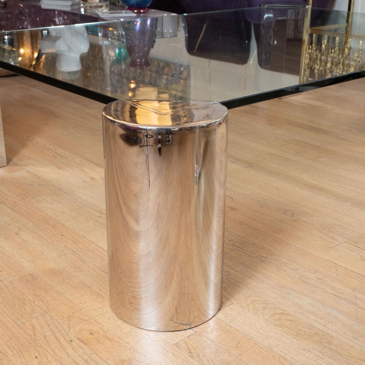 Large glass rectangular cocktail table with four cylindrical polished chrome supports.