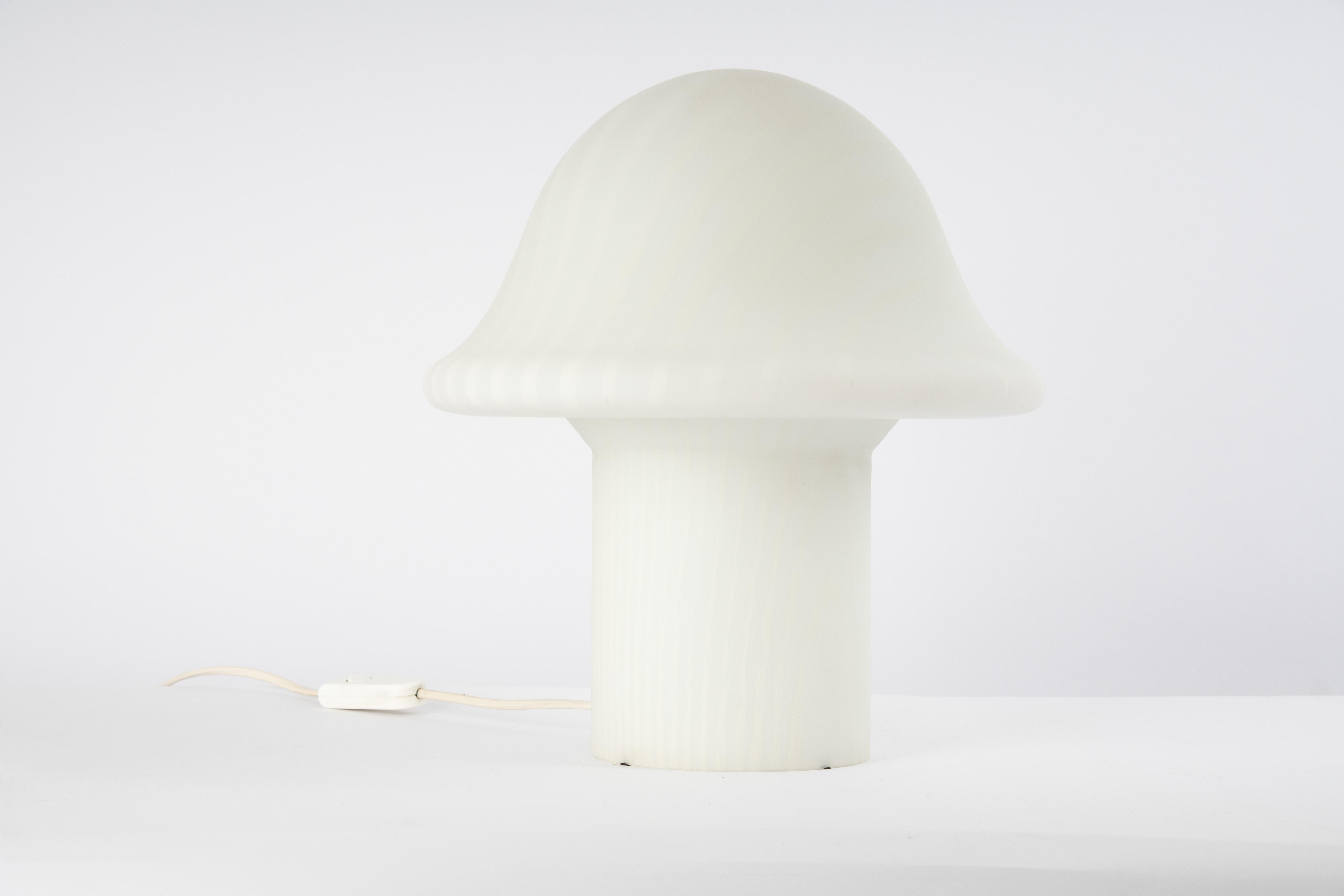 Wonderful midcentury mushroom table lamp by Peill & Putzler, Germany, 1970s.
Made of a single piece of blown and cased glass.
Manufacturer: Peill & Putzler

Stunning glass form and in very good condition. Cleaned, well-wired, and ready to use. Each