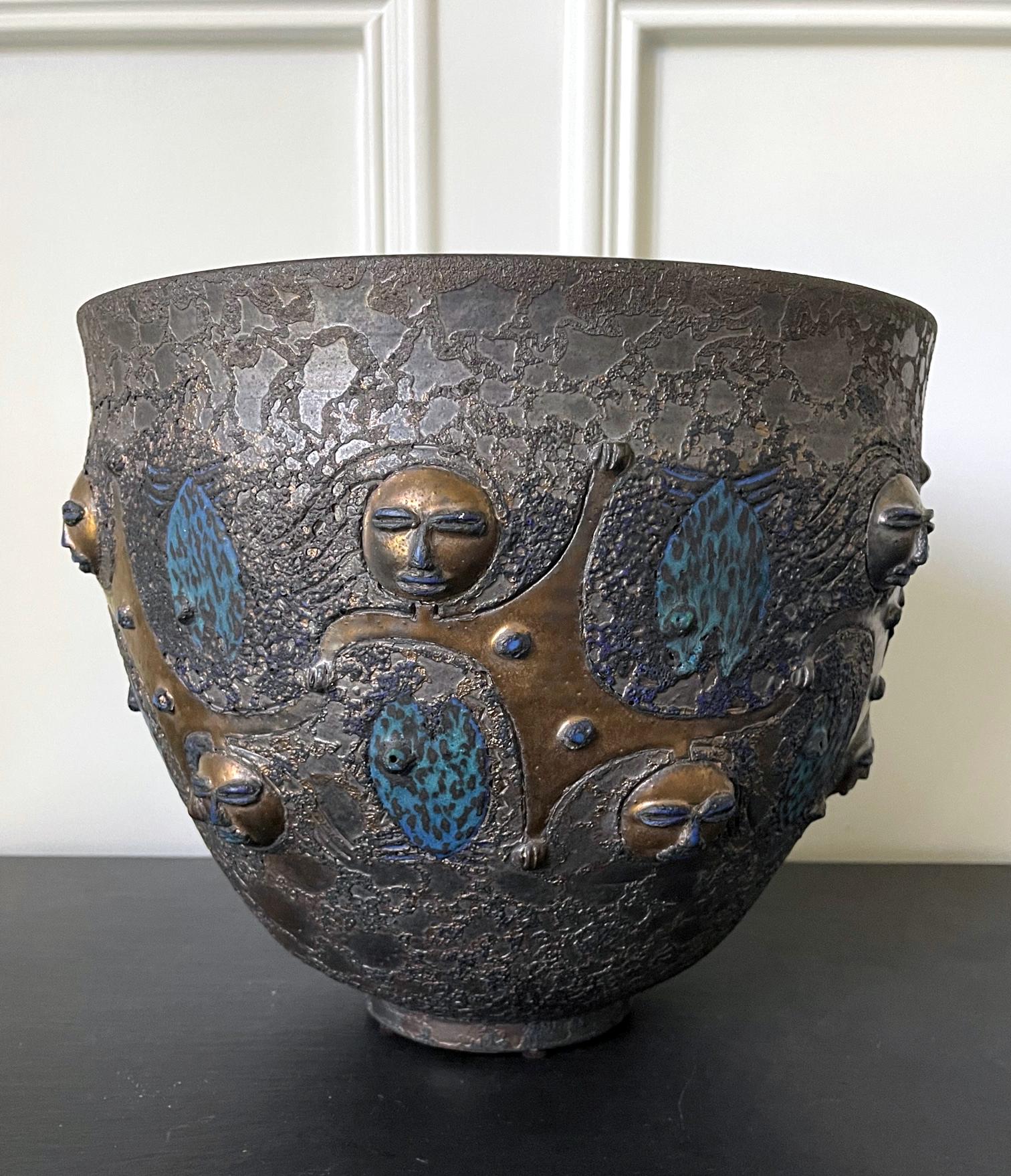 A large and stunning stoneware ceramic vessel in the form of an urn or a deep bowl by American potters Mary and Edwin Scheier (1908-2007;1910-2008) dated to 1984. The darkly glazed vessel features their iconic design of interlinked figures, arranged
