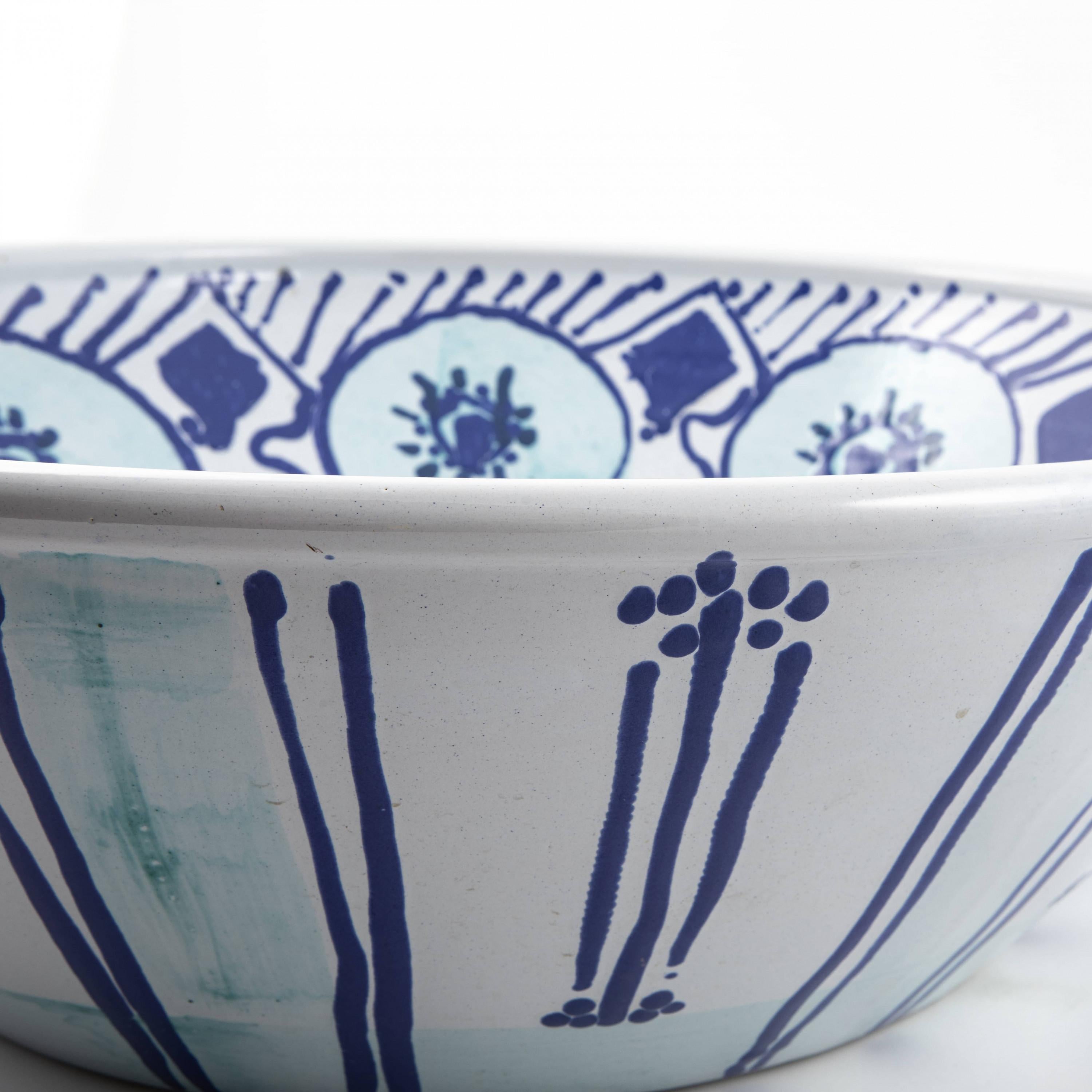 Grande piatto unico in ceramica smaltata.

Base bianca, decorata in blu e verde chiaro.
Realizzato da Dorrit May

Dorrit May ha lavorato per diversi anni con il ceramista e pittore danese Bjørn Wiinblad.