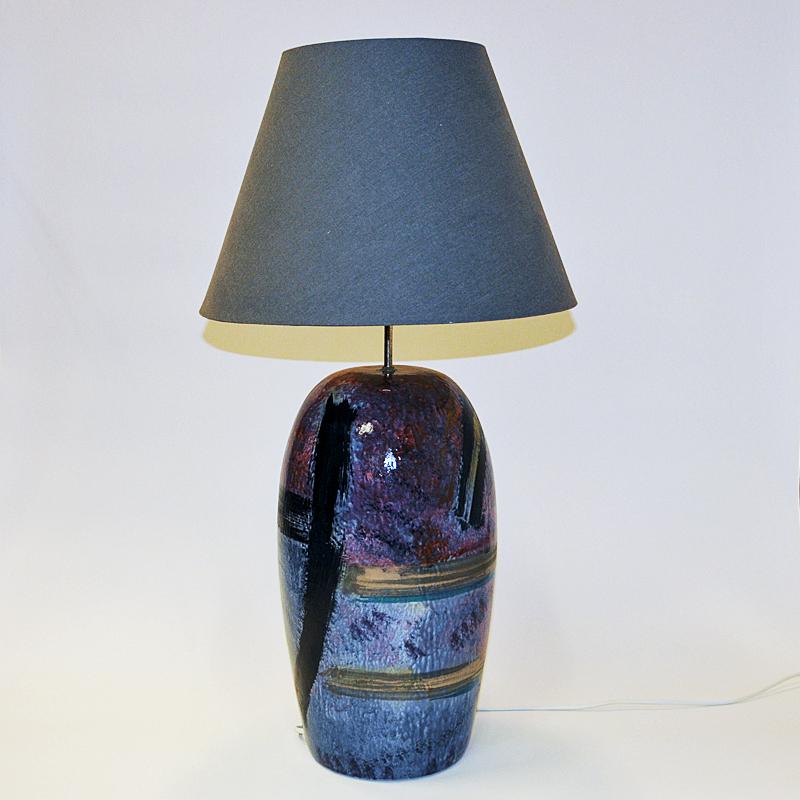 Tolle schwedische Steingut-Tischlampe namens `Creole` mit einer schönen glasierten, handbemalten Oberfläche in einer Farbmischung aus Blau, Lila, Bronze, Beige und Schwarz. Entworfen von Cilla Adelcreutz & Lars Jöransson, Schweden 1980er Jahre.