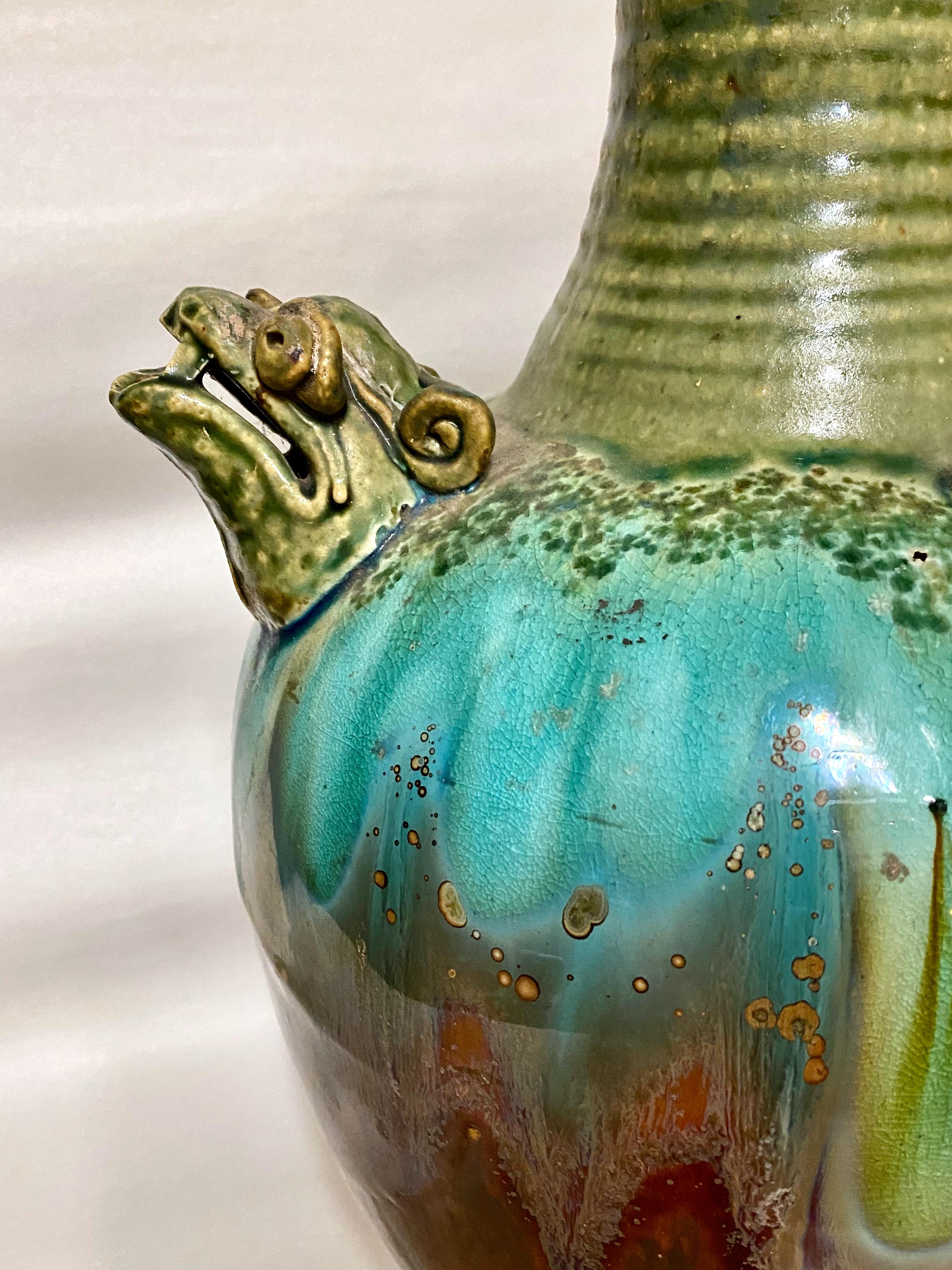 This is a stunning large Chinese glazed terracotta dragon-form ewer. The Double Dragons are cast in fine detail. The ewer derives its inspiration from pottery of the Tang Dynasty; this item most probably dates to the late 19th c. or early 20th