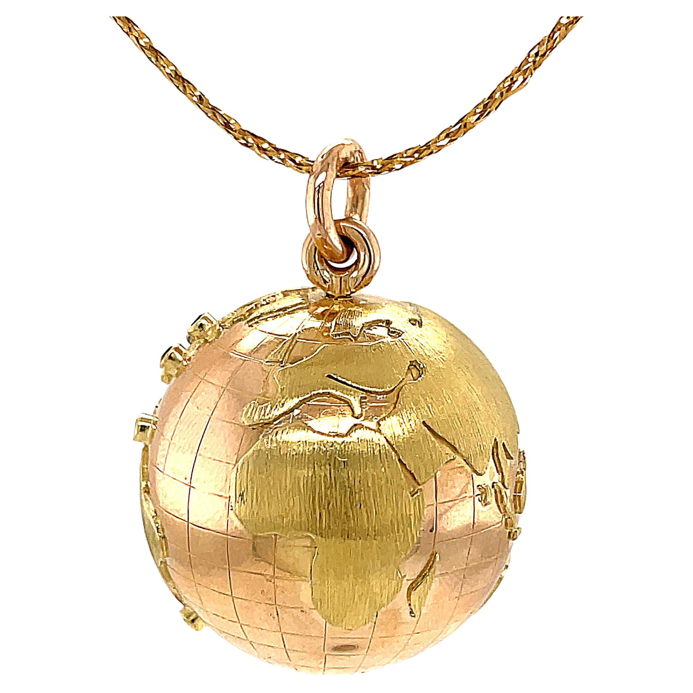 Exceptional large figural globe charm/pendant.  Well-defined applied continents, including the rarely included Antarctica. The globe has an allover grid pattern and is set with rubies, sapphires and a diamond that indicate someone's world travel.